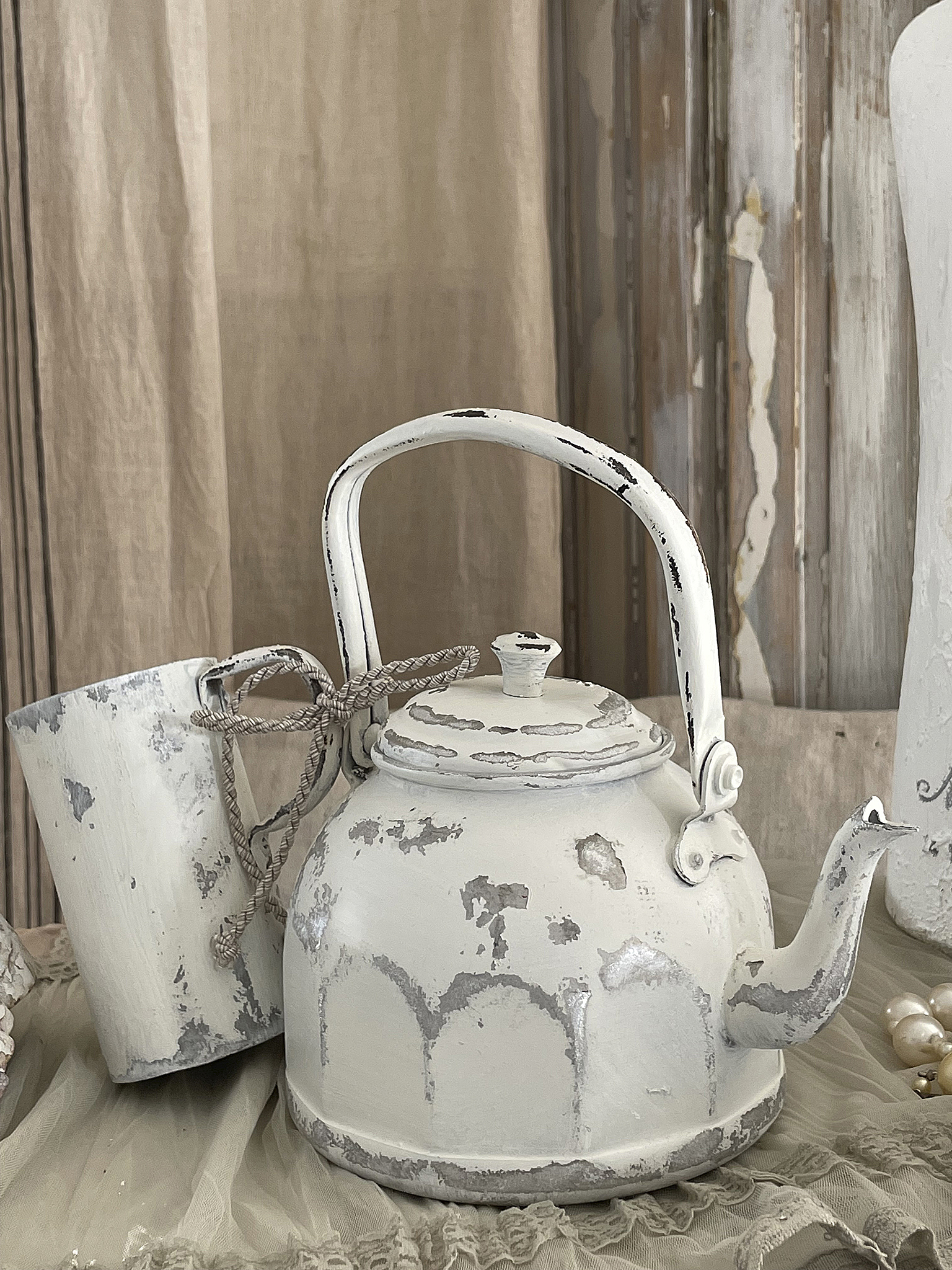 Weißer Teekessel im Vintage-Stil mit Tasse Vintage Teekessel und Tasse in Weiß mit leicht abblätternder Farbe