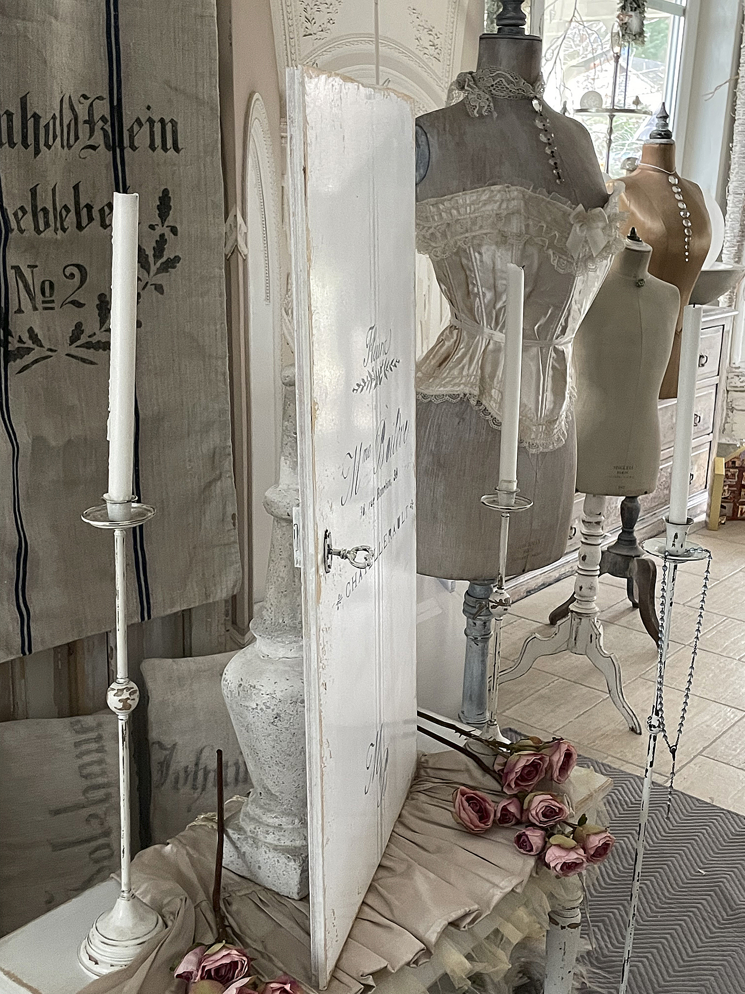 Dekorative Elemente, wie eine geschmackvolle Tür und Mannequins mit vintage Unterwäsche in einem stilvollen Raum.