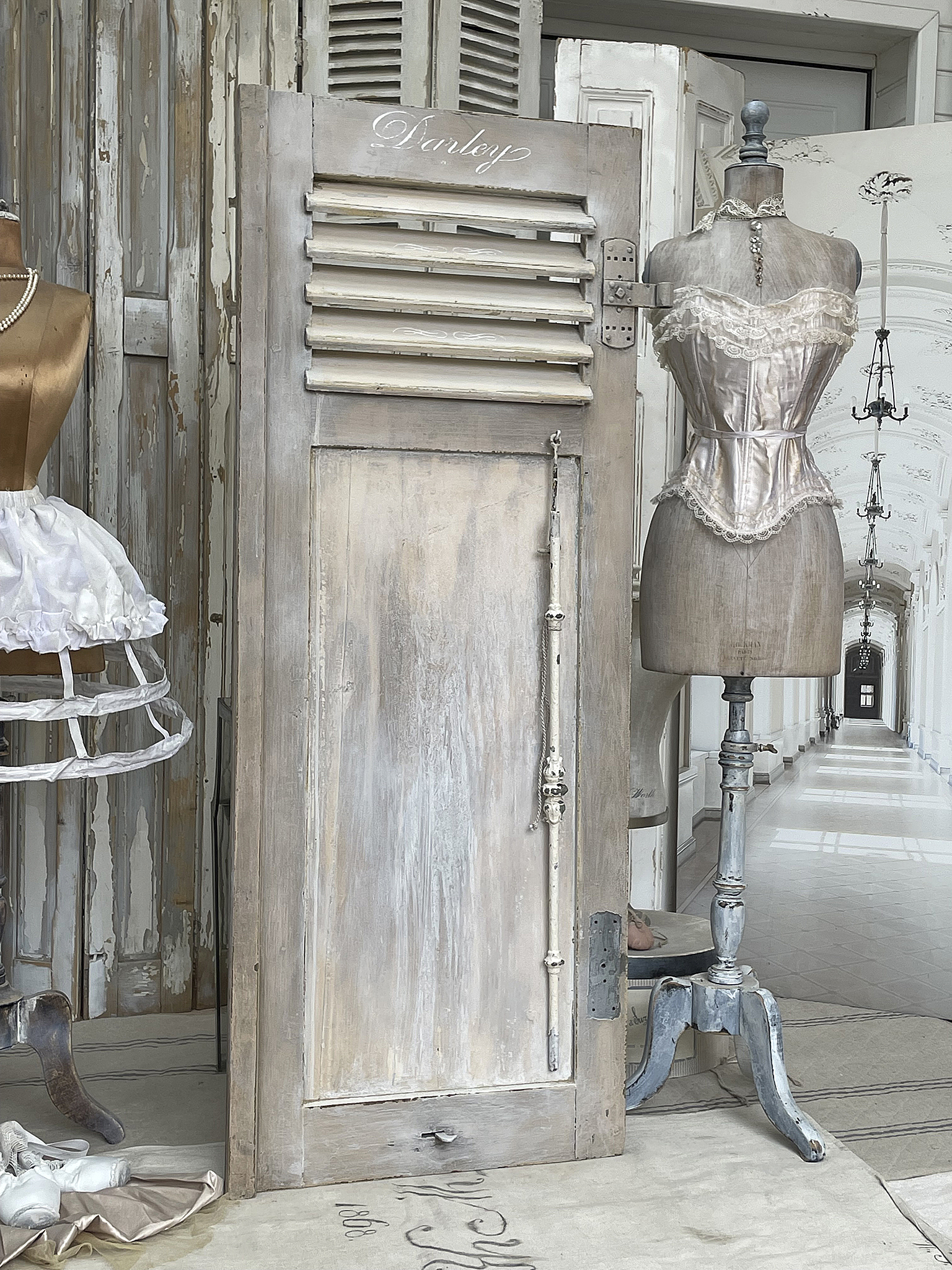 Vintage Garderobe im Shabby-Stil mit Corsage Detailaufnahme einer vintage Garderobe neben einer Holzpuppe in einem eleganten Raum