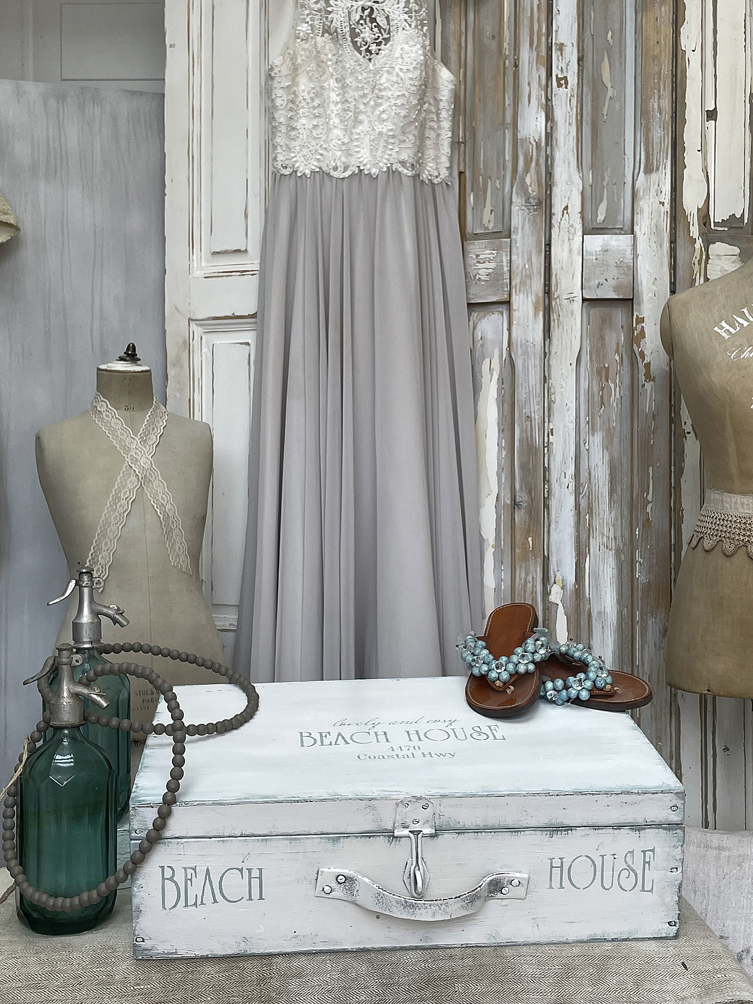 Elegantes graues Kleid mit Spitze für besondere Anlässe Elegantes graues Kleid mit Spitze, Sandalen und Vintage-Dekoration in einem Wohnambiente