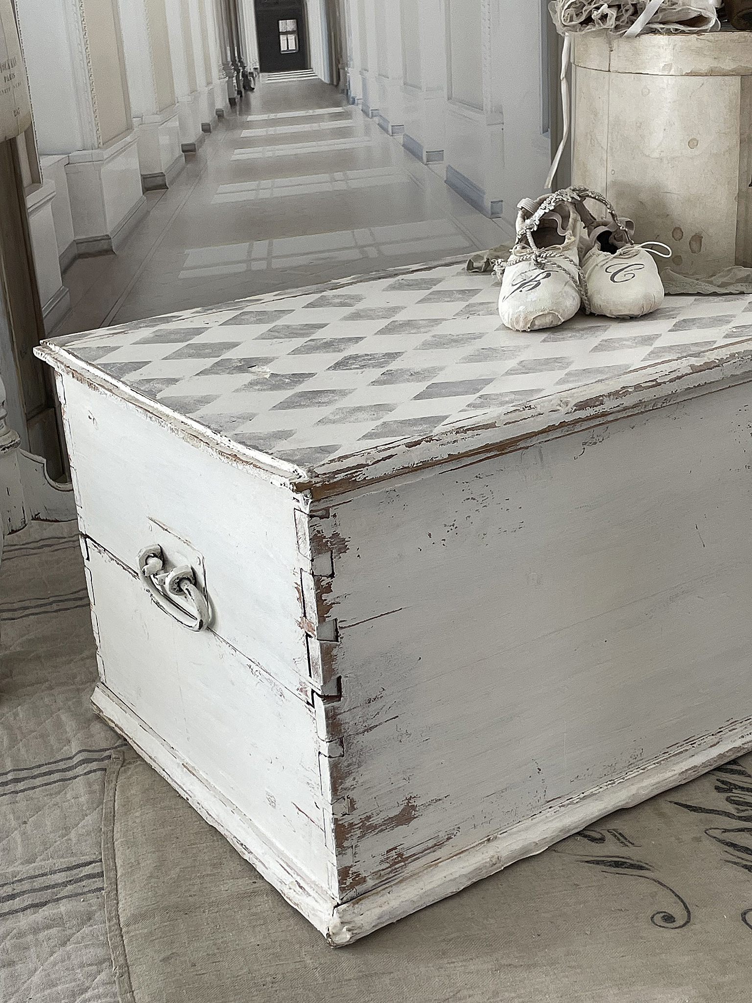 Vintage Holzkiste mit Ballettschuhen auf einem gemusterten Deckel Holzkiste im Vintage-Stil mit Ballettschuhen auf der oberen Fläche, vor einem eleganten Hintergrund