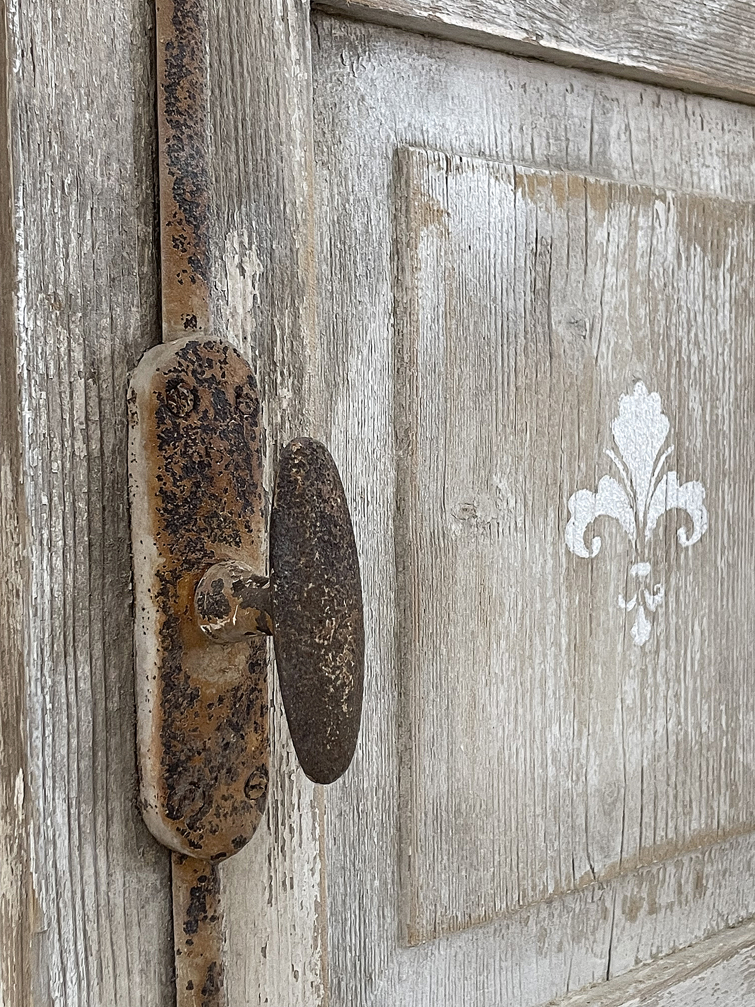 Detailaufnahme einer antiken Tür mit rustikalem Schloss und dekorativen Elementen Nahaufnahme eines alten Schlosses an einer Holzoberfläche mit einem blauen Muster