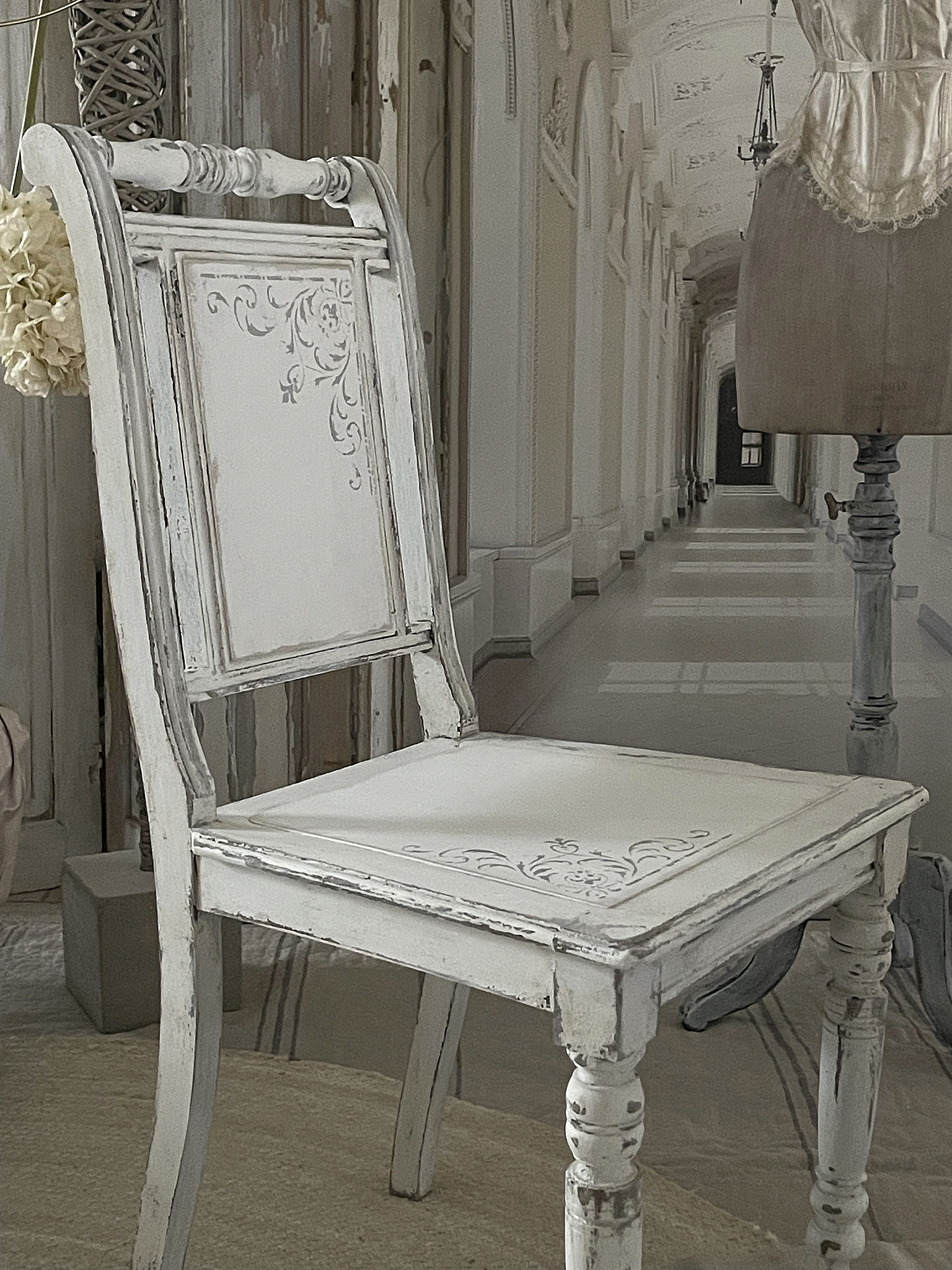 Klassischer vintage Stuhl im eleganten Ambiente Weißer vintage Stuhl mit filigranen Verzierungen in einem eleganten Flur