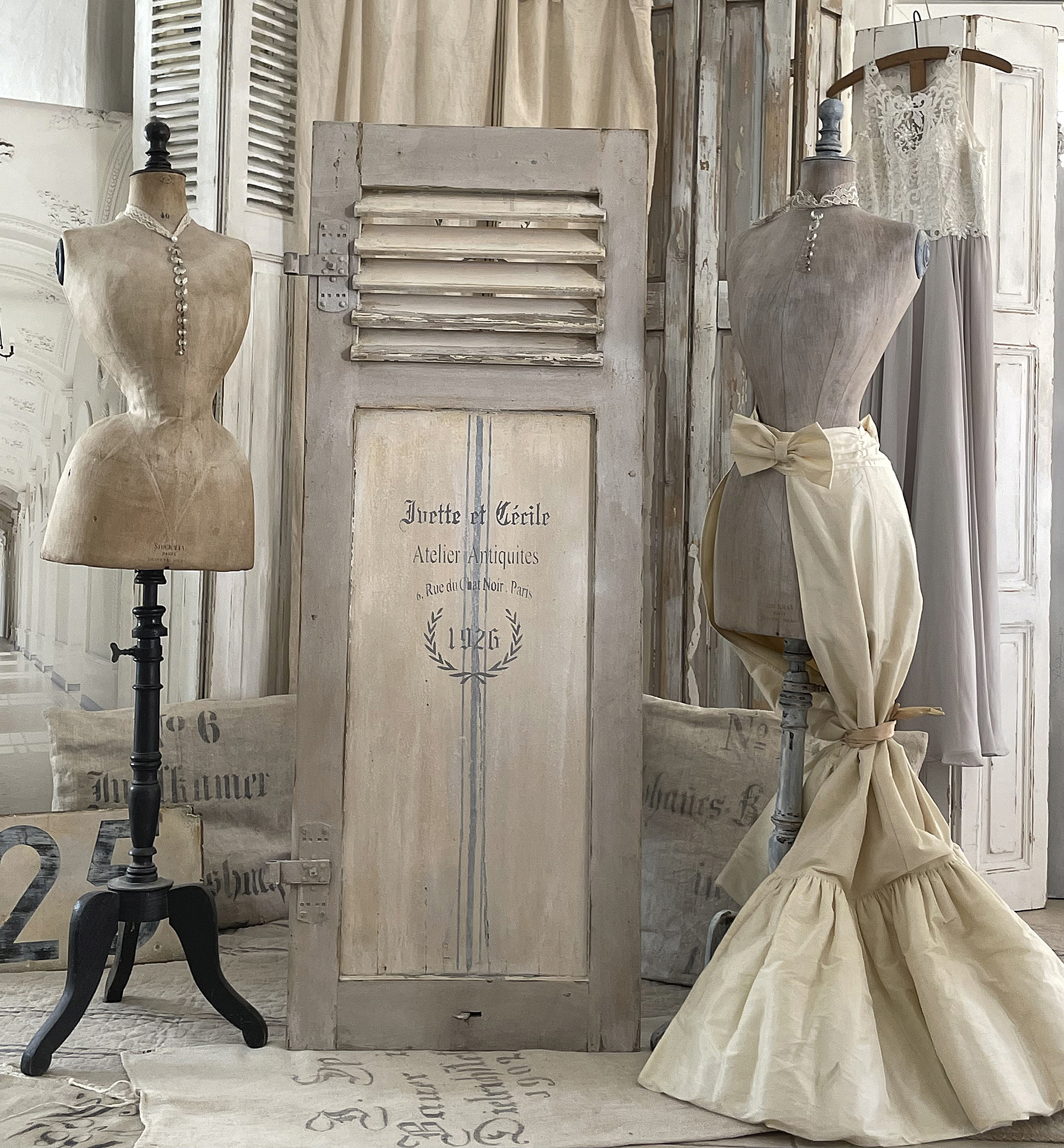 Antikes Atelier mit Schaufensterpuppen und Vintage-Stilen Zwei stilvolle Schaufensterpuppen in einem antiken Atelier mit einer romantischen Dekoration und Vintage-Elementen