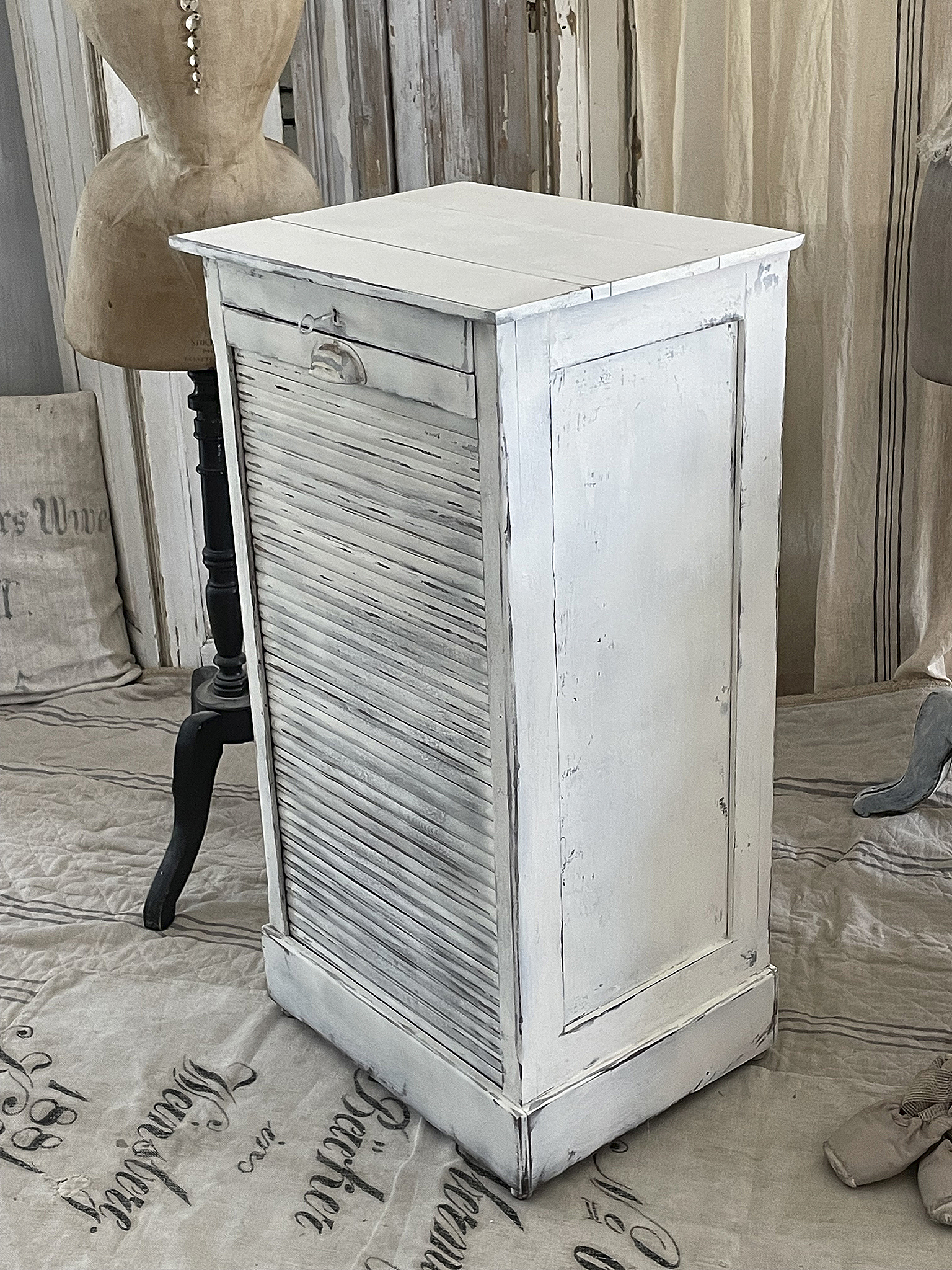 Vintage Holzschrank mit Lamellentüren für stilvolle Aufbewahrung Hochwertiger weißer Vintage-Schrank mit Lamellentüren auf einem stilvollen Hintergrund