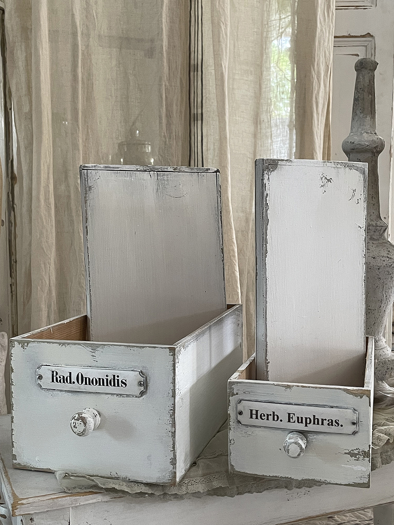 Vintage Aufbewahrungsboxen mit Beschriftung Zwei rustikale Holzkästen mit den Beschriftungen Rad. Ononidis und Herb. Euphras. auf einem Tisch