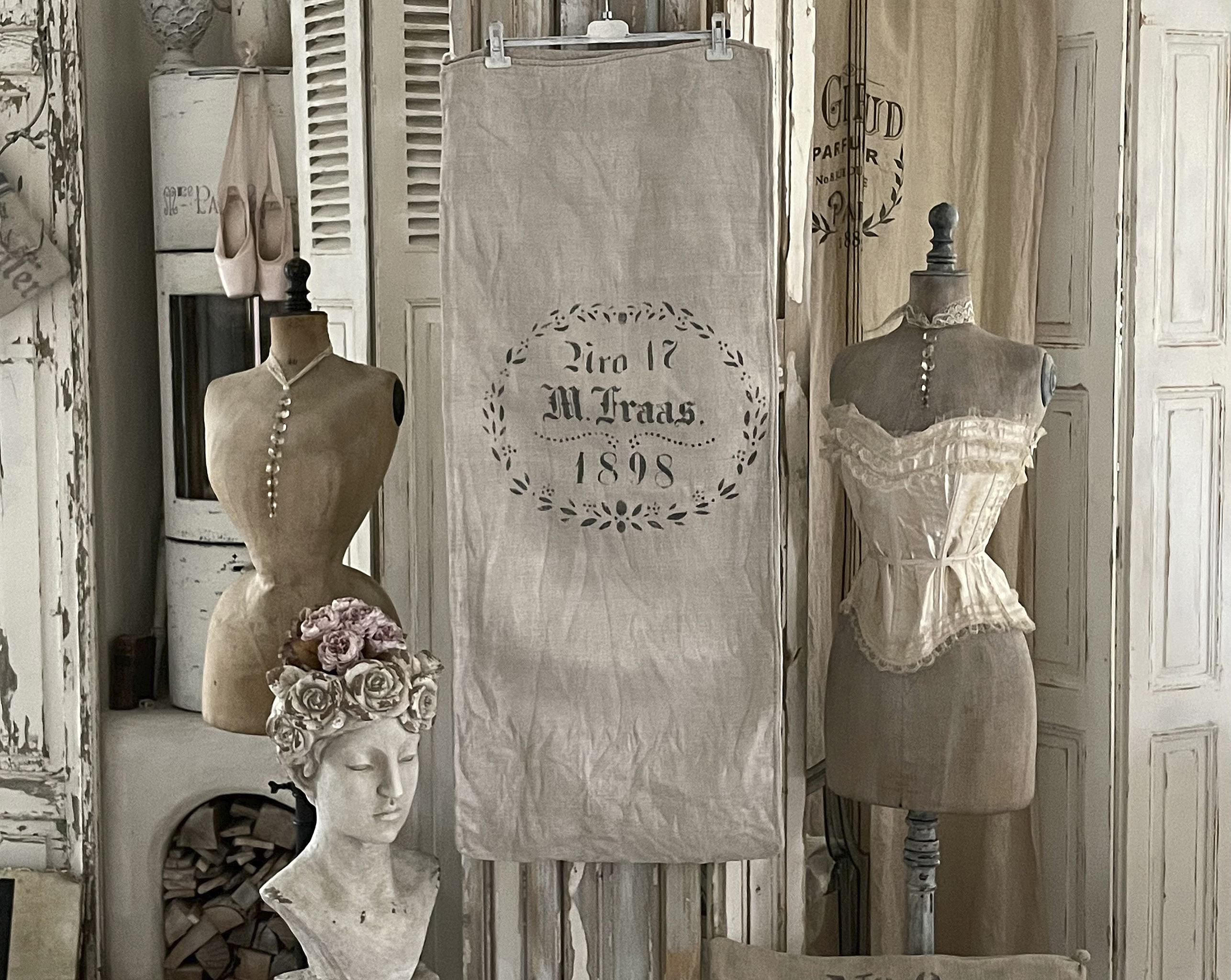 Dekorative Vintage-Mannequins mit historischem Textil und Blumenschmuck in einem gemütlichen Raum