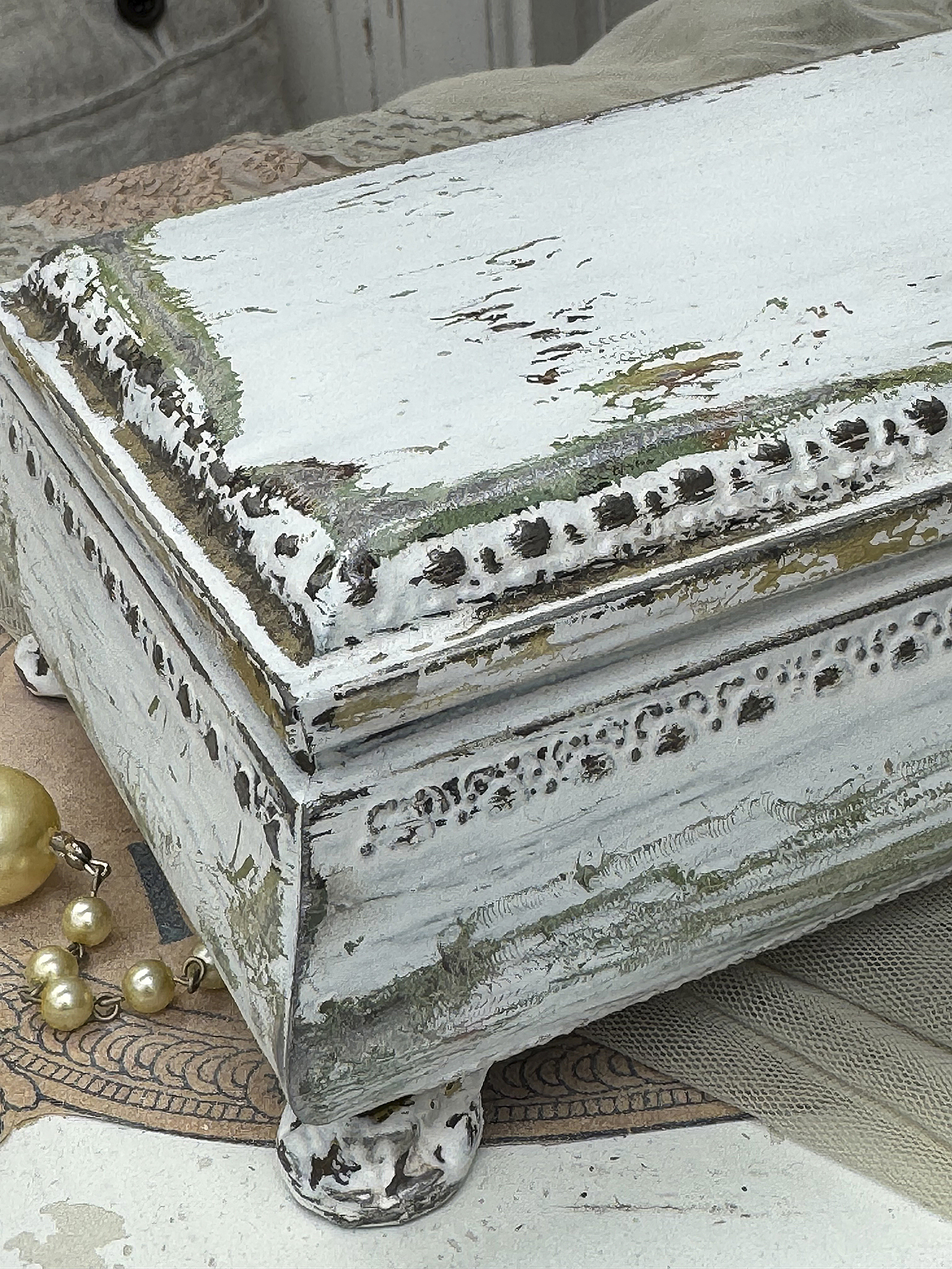 Rustikale Aufbewahrungsbox mit antikem Finish Antike stilvolle Box mit geschmackvoller Patina auf einer dekorativen Unterlage