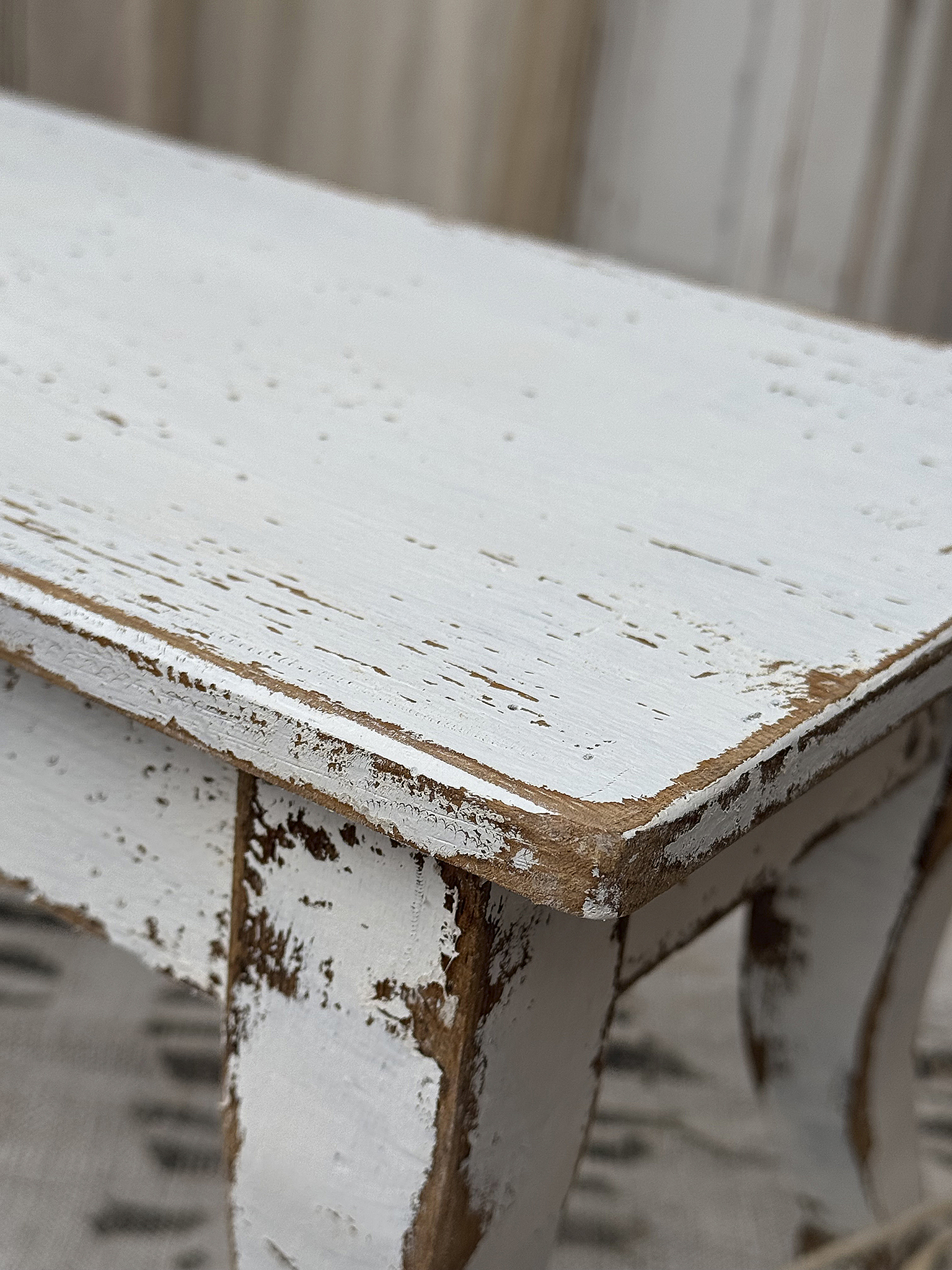 Weißer Vintage Tisch mit abgeriebenen Kanten Nahaufnahme eines weißen Vintage Tisches mit abgeriebenen und verwitterten Kanten