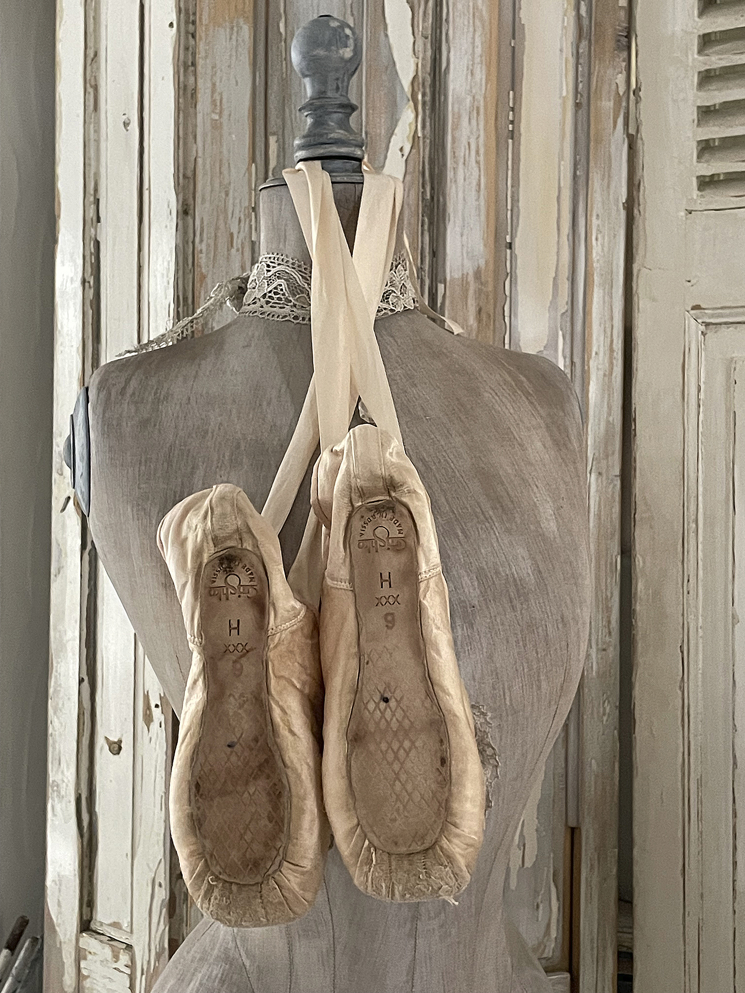 Ballettschuhe an einer Schneiderpuppe aufgehängt Ballettschuhe hängen an einer Schneiderpuppe, detailierter Blick auf die Sohle und Riemen.