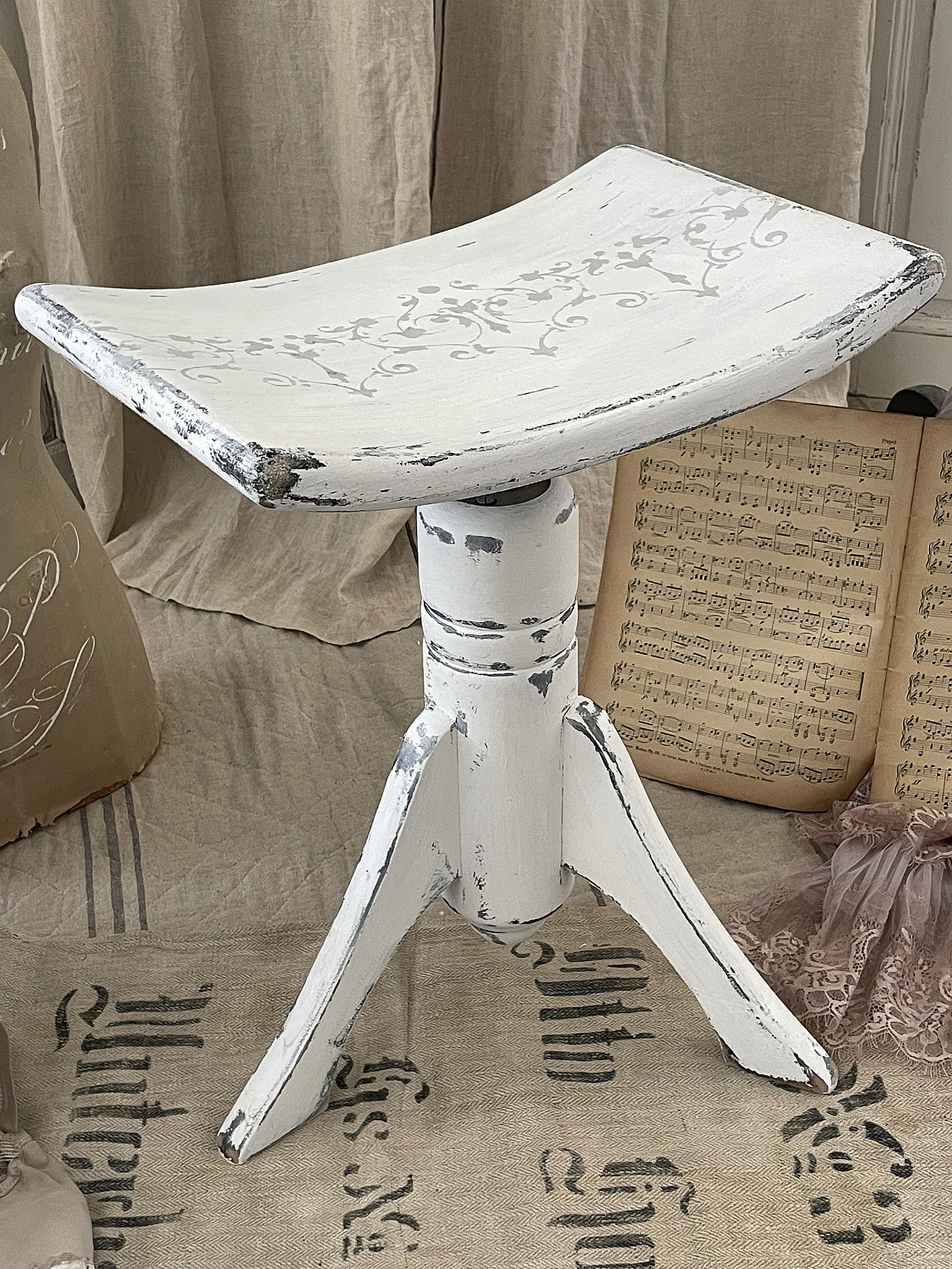 Hocker im Vintage-Stil mit geschwungenem Sitz und nostalgischen Verzierungen