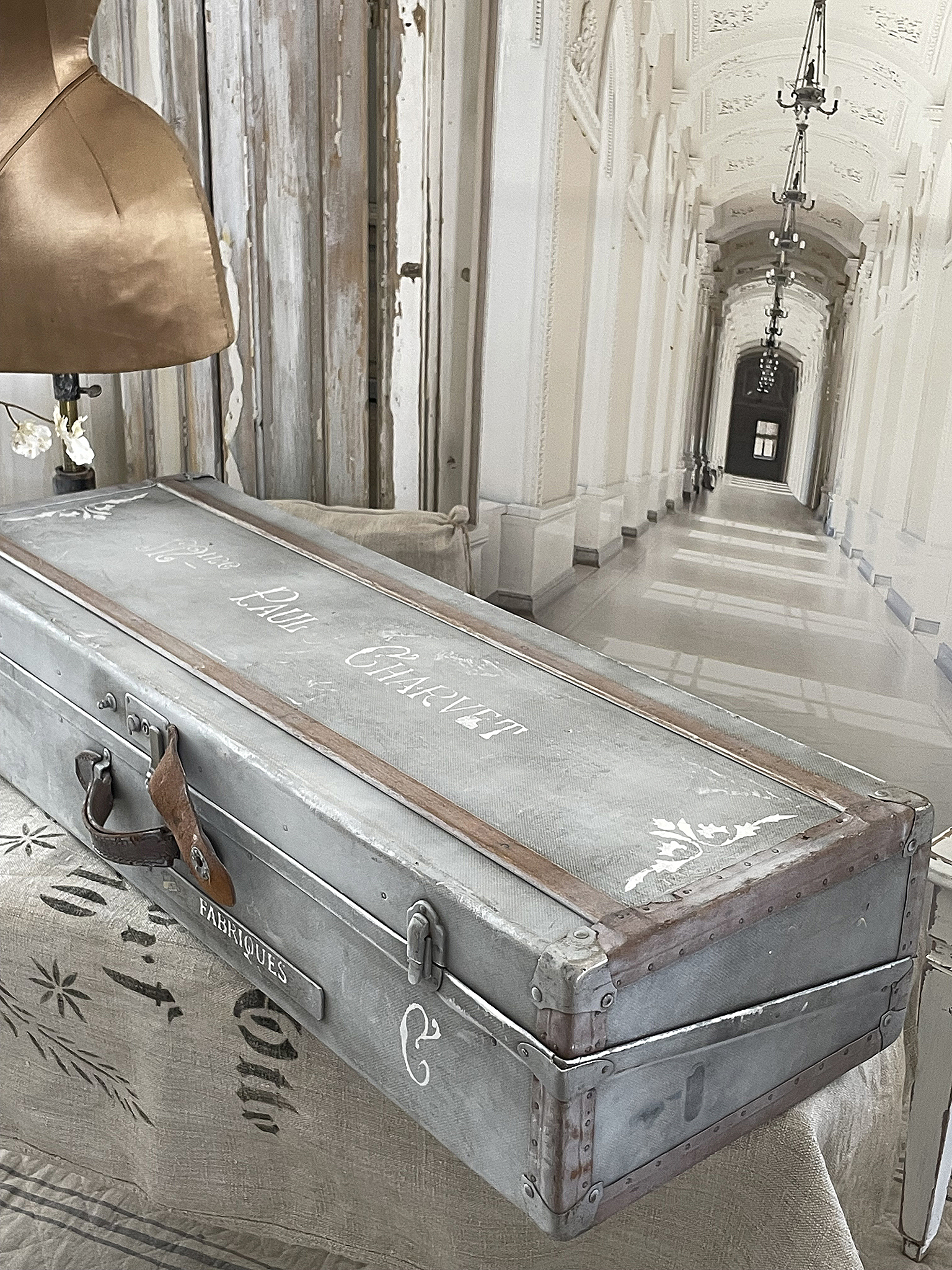 Vintage Koffer mit nostalgischem Design Ein eleganter, grauer Vintage Koffer auf einem Tisch in einer stilvollen Innenausstattung.