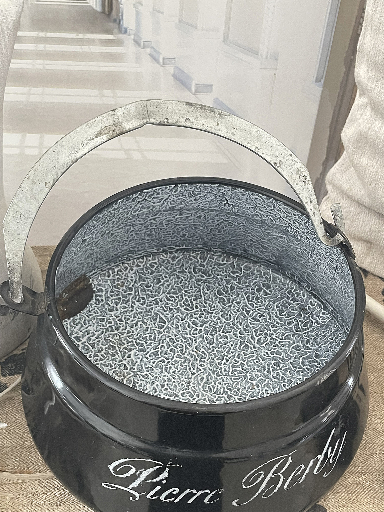 Schwarzer Metallbehälter mit grauem Innenleben und Griff