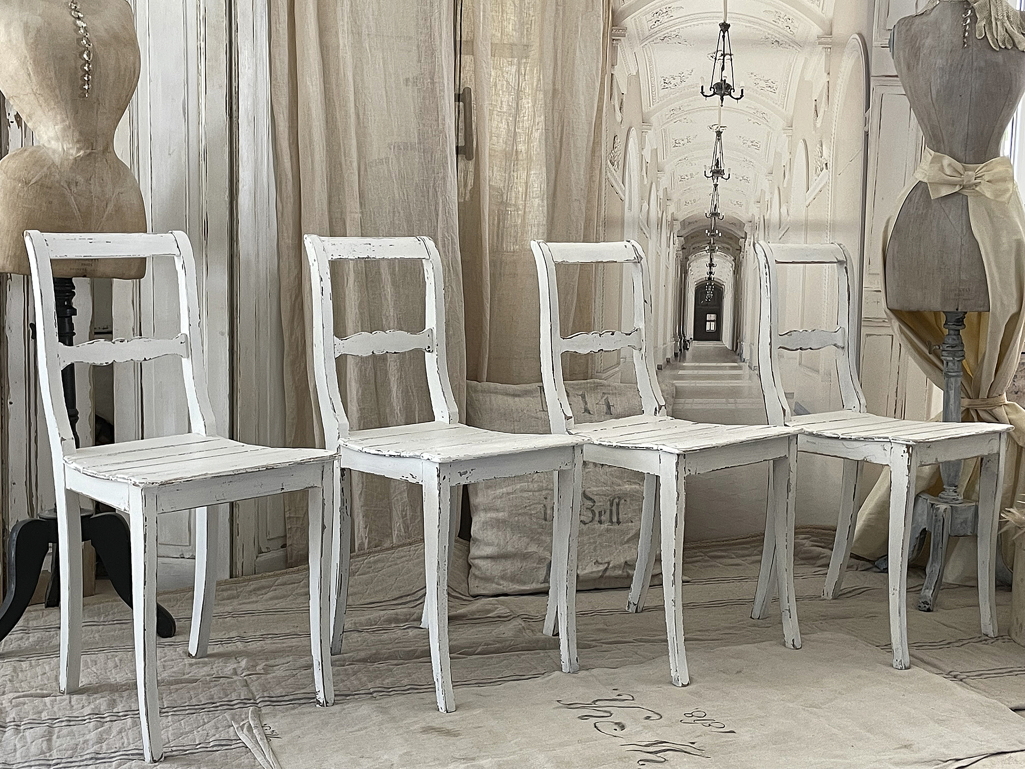 Elegante weiße Stühle im vintage Stil Vierteiliges Set weißer Stühle im vintage Design, platziert in einem stilvollen Raum