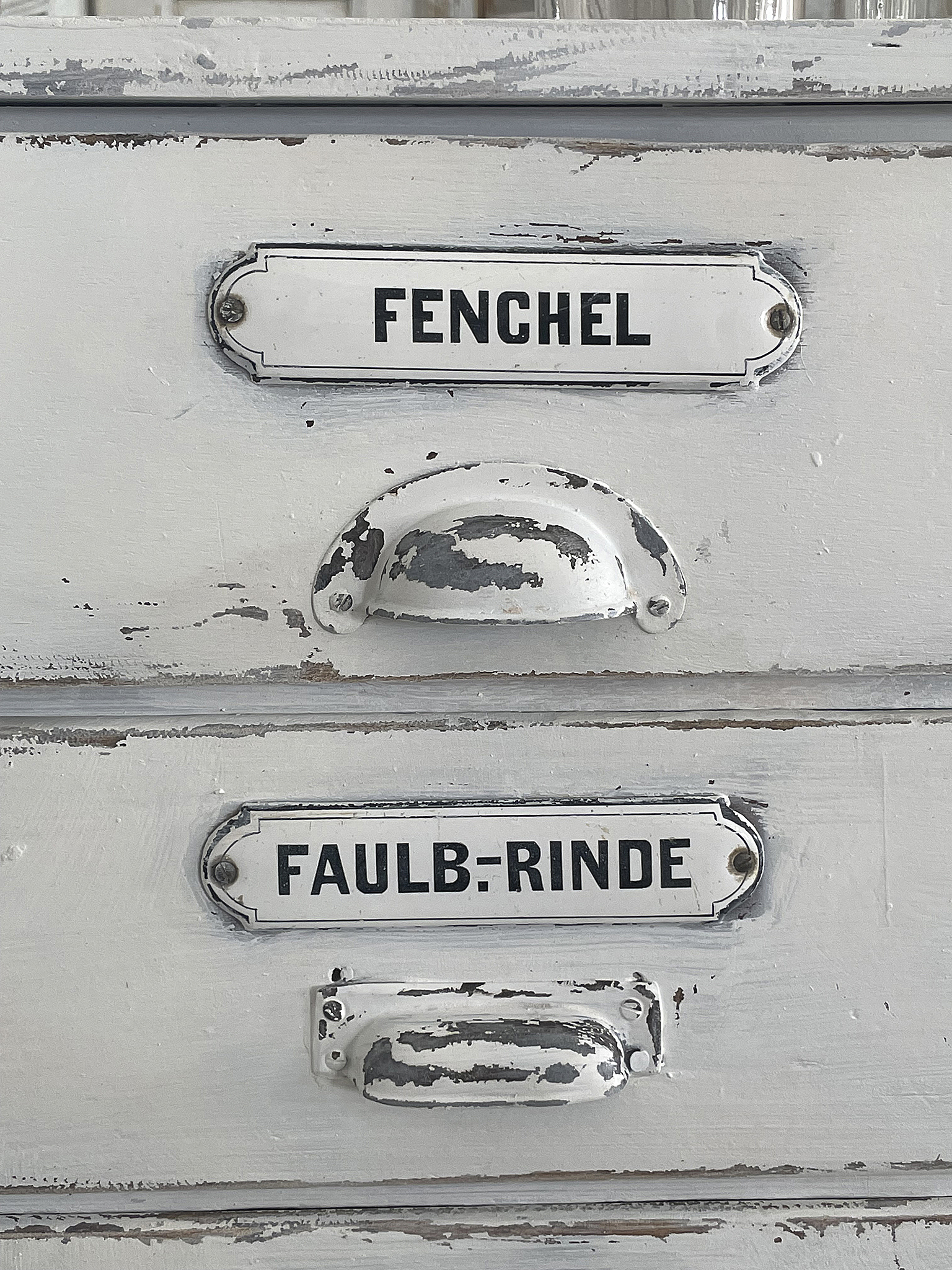 Vintage Schublade beschriftet mit Fenchel und Faulb-Rinde Detailaufnahme einer Vintage-Kommode mit Schubladenbeschriftungen für Fenchel und Faulb-Rinde