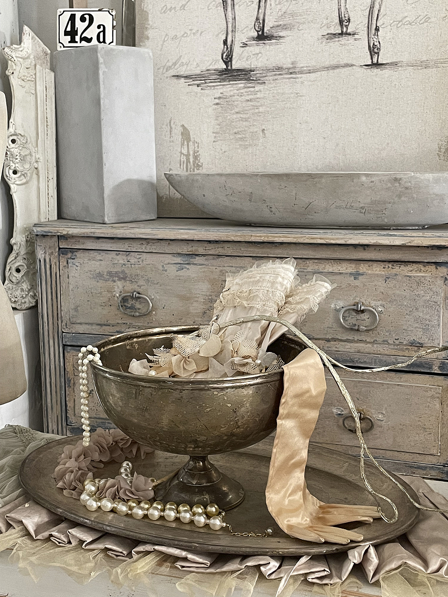 Elegante Deko mit Vintage-Charme, Perlen und Stoffelementen Antike Schüssel mit Dekoration, darunter Perlen und zarte Stoffe auf einem rustikalen Tisch