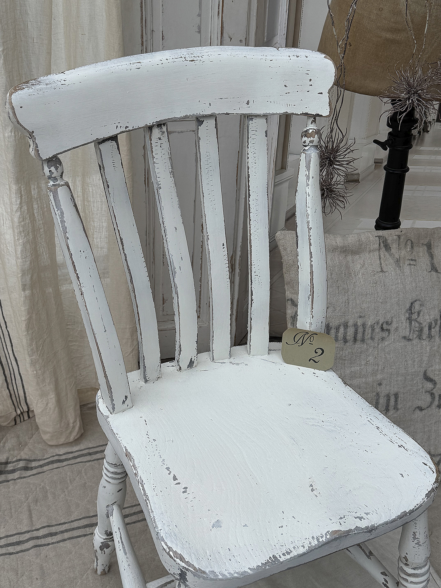 Reizender alter Bauernstuhl im weißen Shabby-Kleid