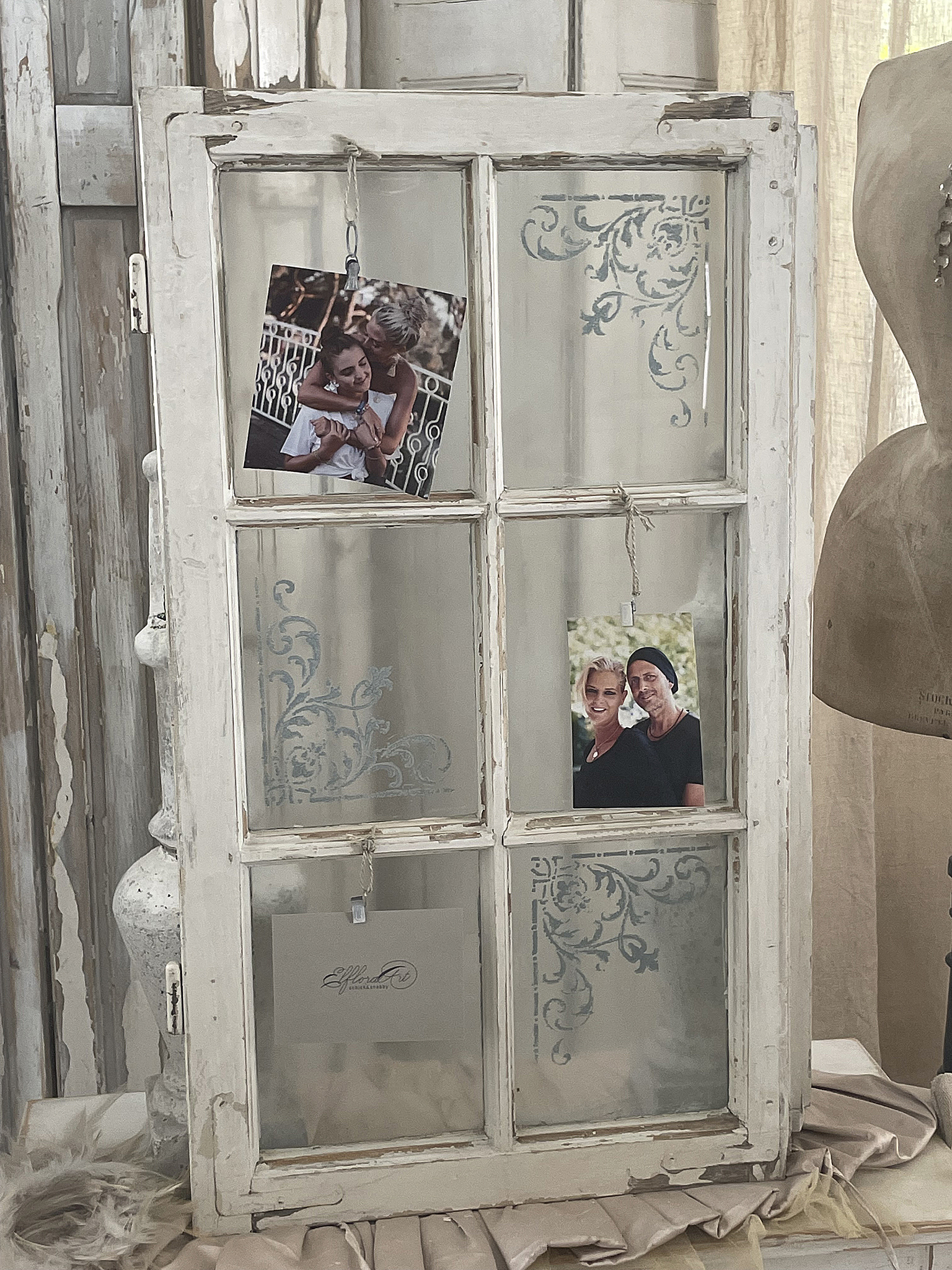 Vintage Fenster mit Fotos und dekorativem Design Altes Fenster mit zwei hängenden Fotos in einem rustikalen Ambiente