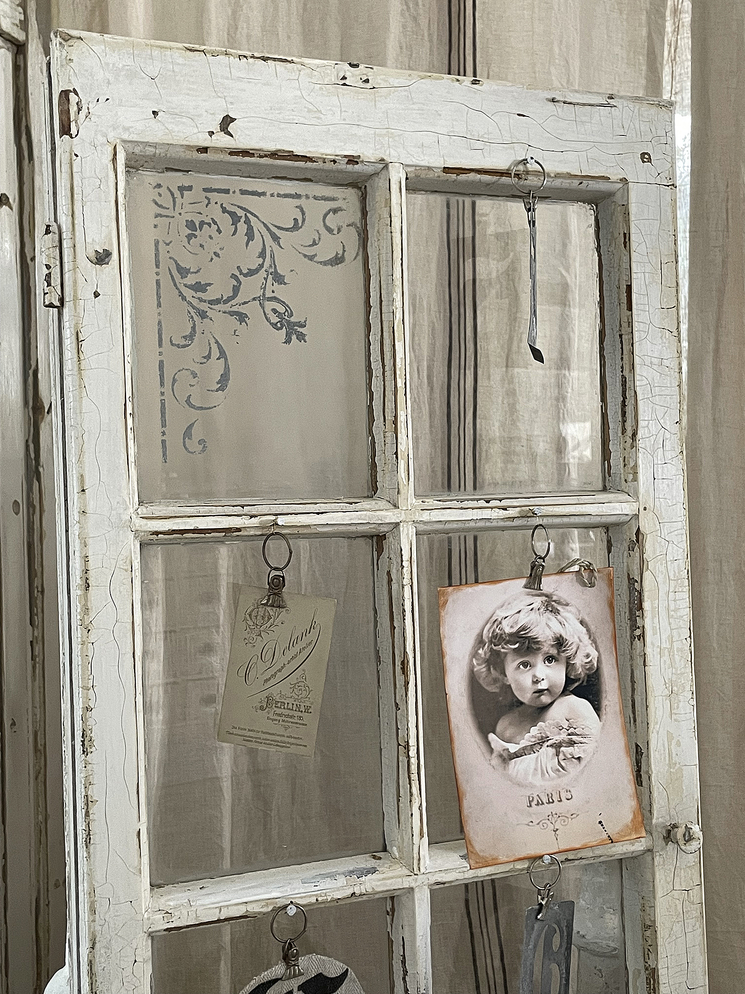 Vintage Fenster mit nostalgischen Erinnerungen und Dekorationen Detailaufnahme eines alten Fensters mit Bildern und Karten, die an den Rahmen hängen.