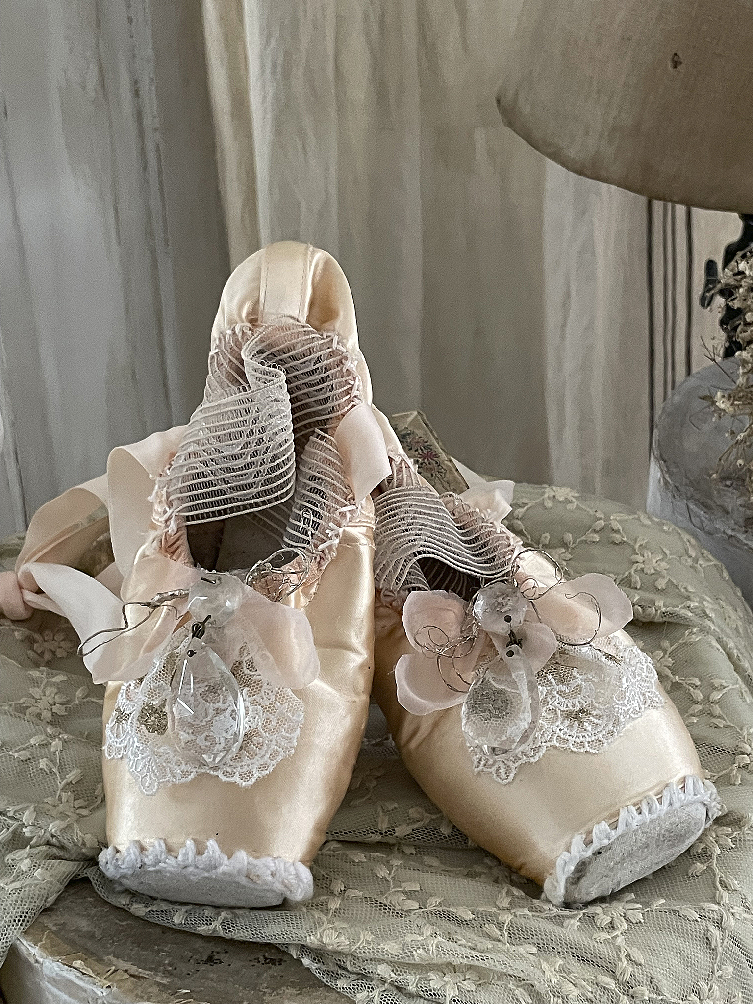 Elegante Ballettschuhe mit zarten Details Zwei klassische Ballettschuhe in zartem Rosa mit Rüschen und Schnürungen auf einem eleganten Untergrund