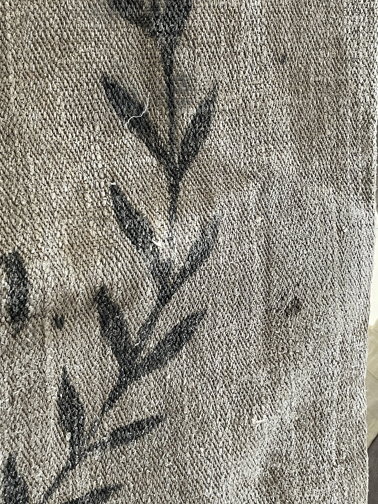 Vintage Teppich mit floralem Muster in Grau und Schwarz Detailaufnahme eines grauen Teppichs mit schwarzen Pflanzenmotiven
