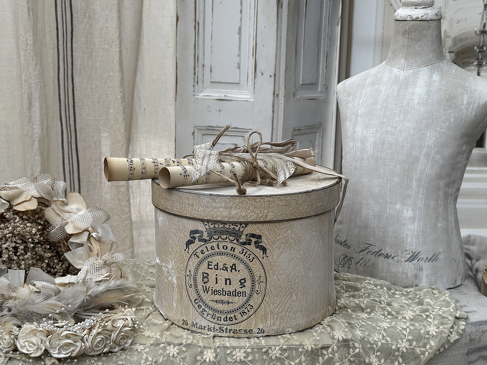 Dekorative Aufbewahrungsschachtel mit nostalgischem Design Dekorative Box mit verzierten Details, umgeben von einer Blütenkranz und einem Schneiderpuppen