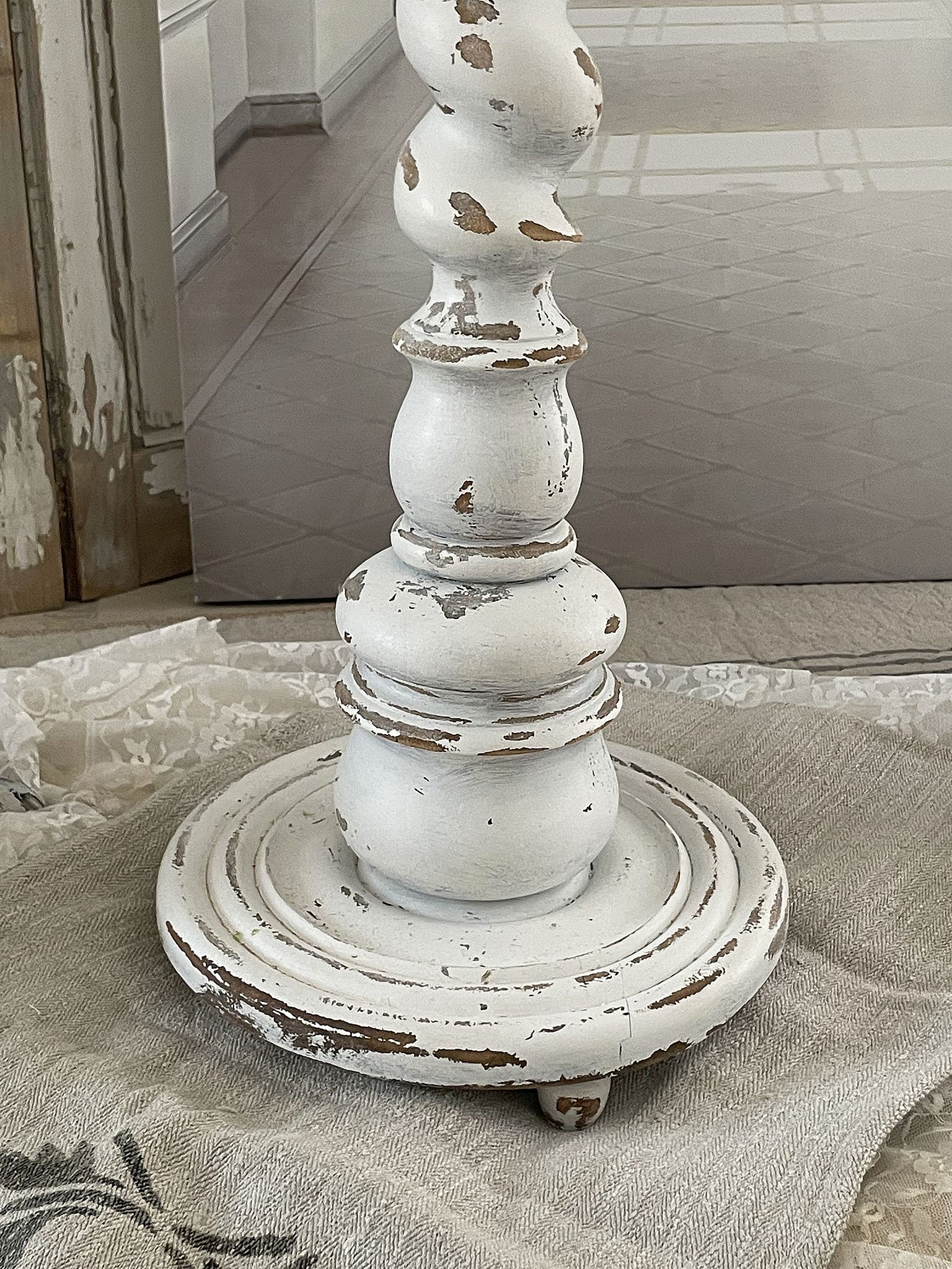 Elegante weiße Tischlampe mit Vintage-Charme Nahaufnahme einer weißen Tischlampe mit nostalgischem Design und abgeriebenem Holzfinish