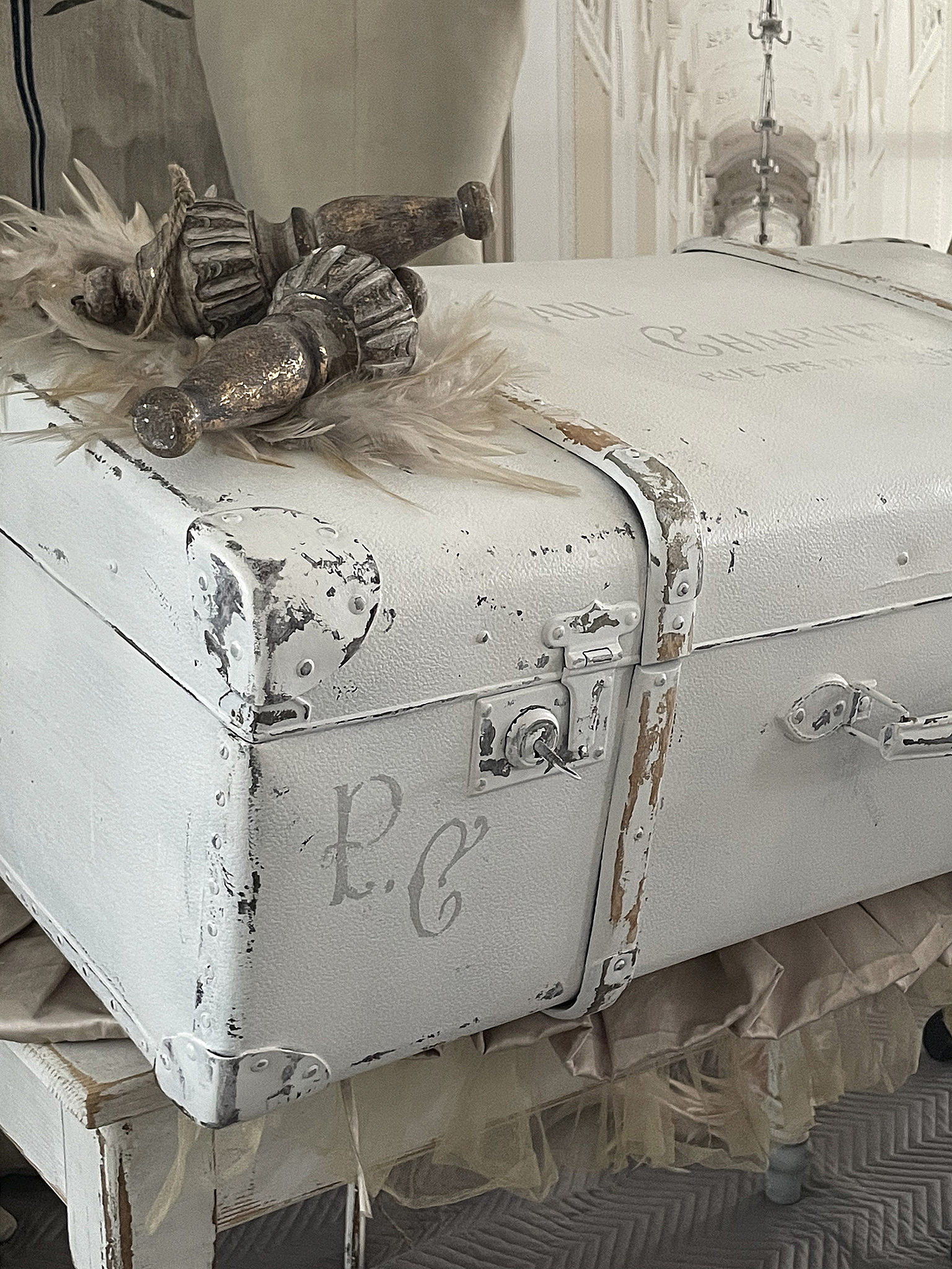 Antike Reisekiste mit nostalgischem Charme Weiß gefärbte Reisekiste mit vintage Details und Dekoration