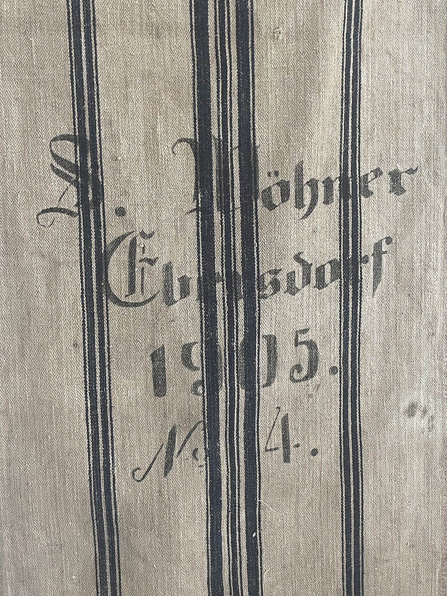 Detailaufnahme eines historischen Stoffes mit der Aufschrift S. Möhner, Glödsdorf, 1905, Nr. 14