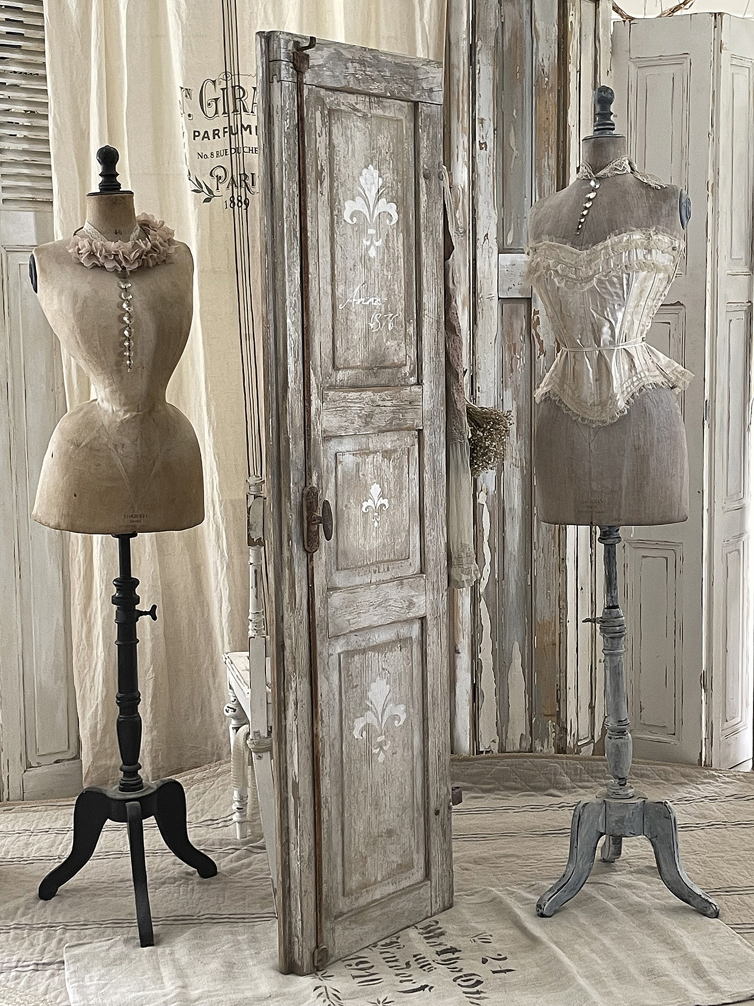 Elegante Schneiderpuppen und vintage Tür im stilvollen Interieur Schneiderpuppen aus Vintage-Materialien mit einer alten Tür im Hintergrund in einem dekorativen Raum
