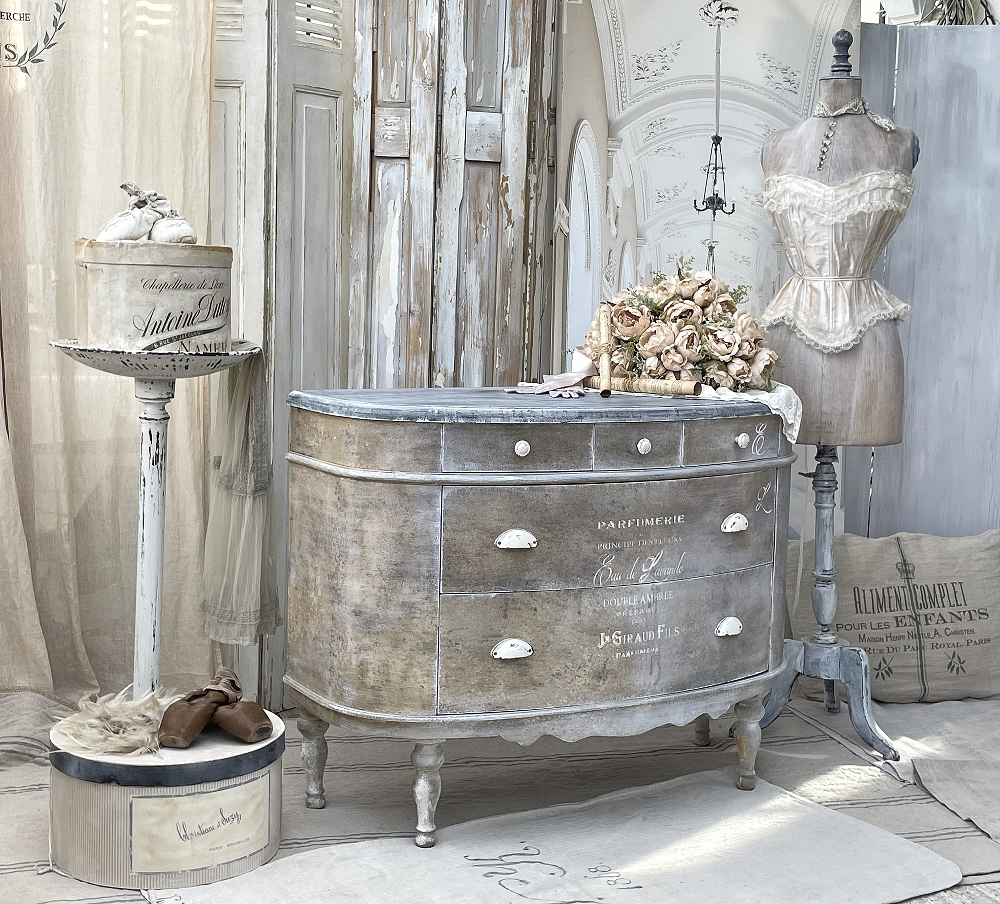 Vintage Kommode im französischen Landhausstil mit Blumendekoration Antike Kommode mit geschwungener Form, verziert mit einer Blumengeste und einer Schneiderpuppe
