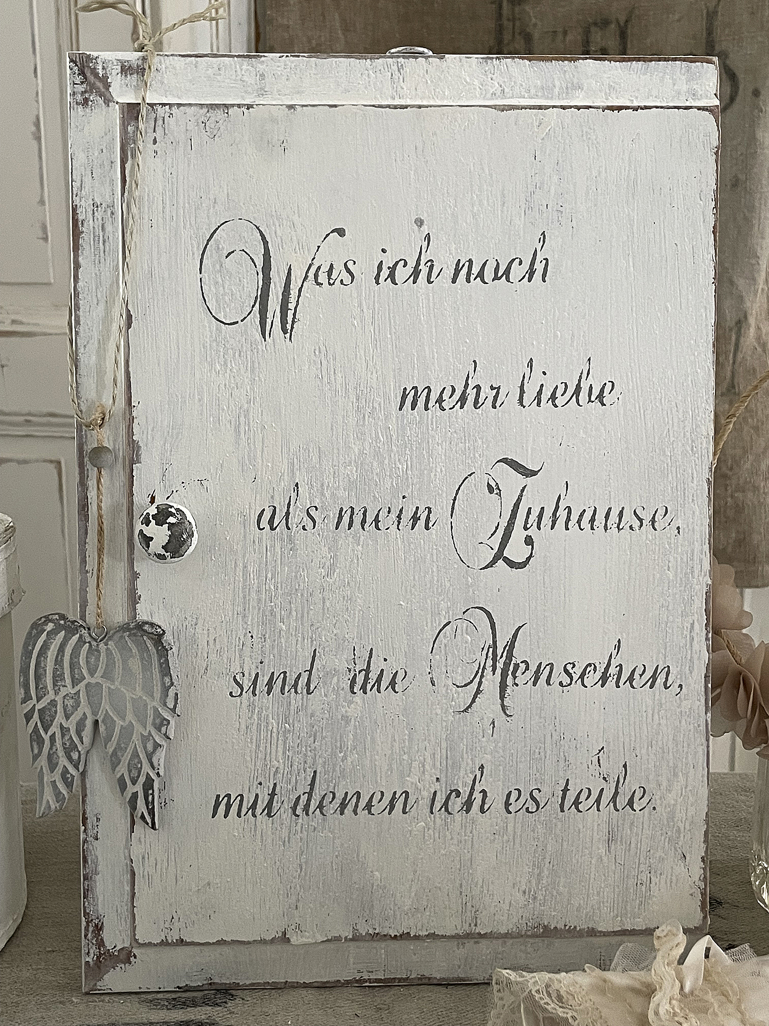 Künstlerische Wanddeko mit Liebesbotschaft Dekorative Holztafel mit dem Text über Zuhause und die Menschen, die man liebt.