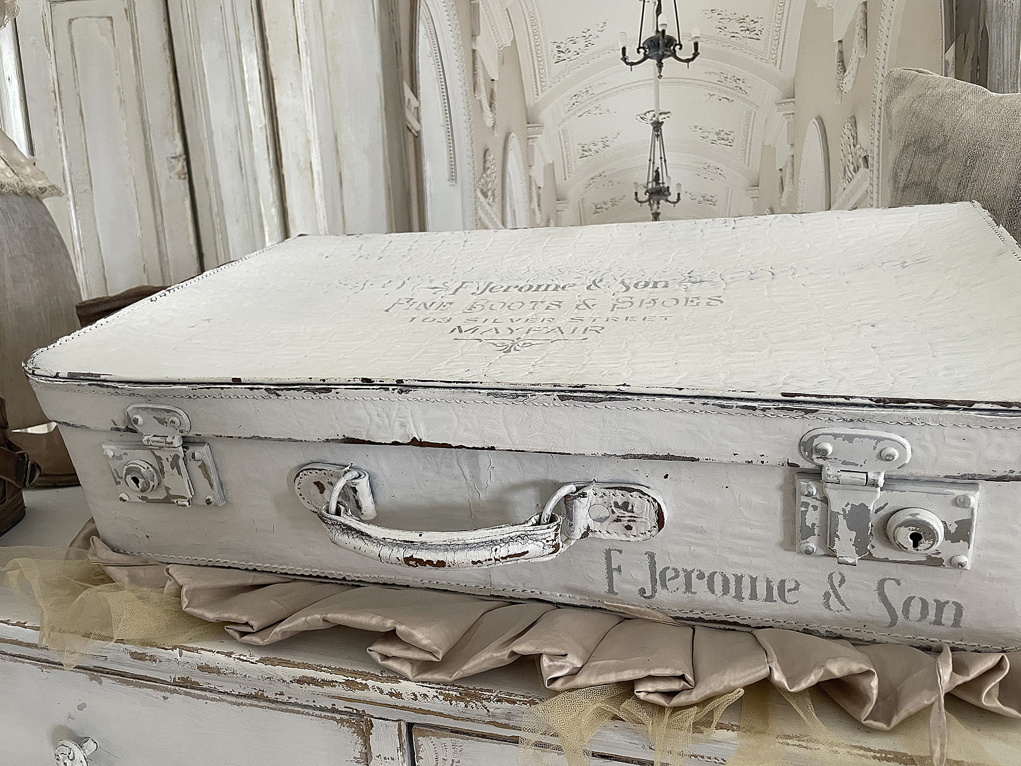 Alter Koffer von F. Jerome & Son auf einer Tischdecke, dekorativ und nostalgisch