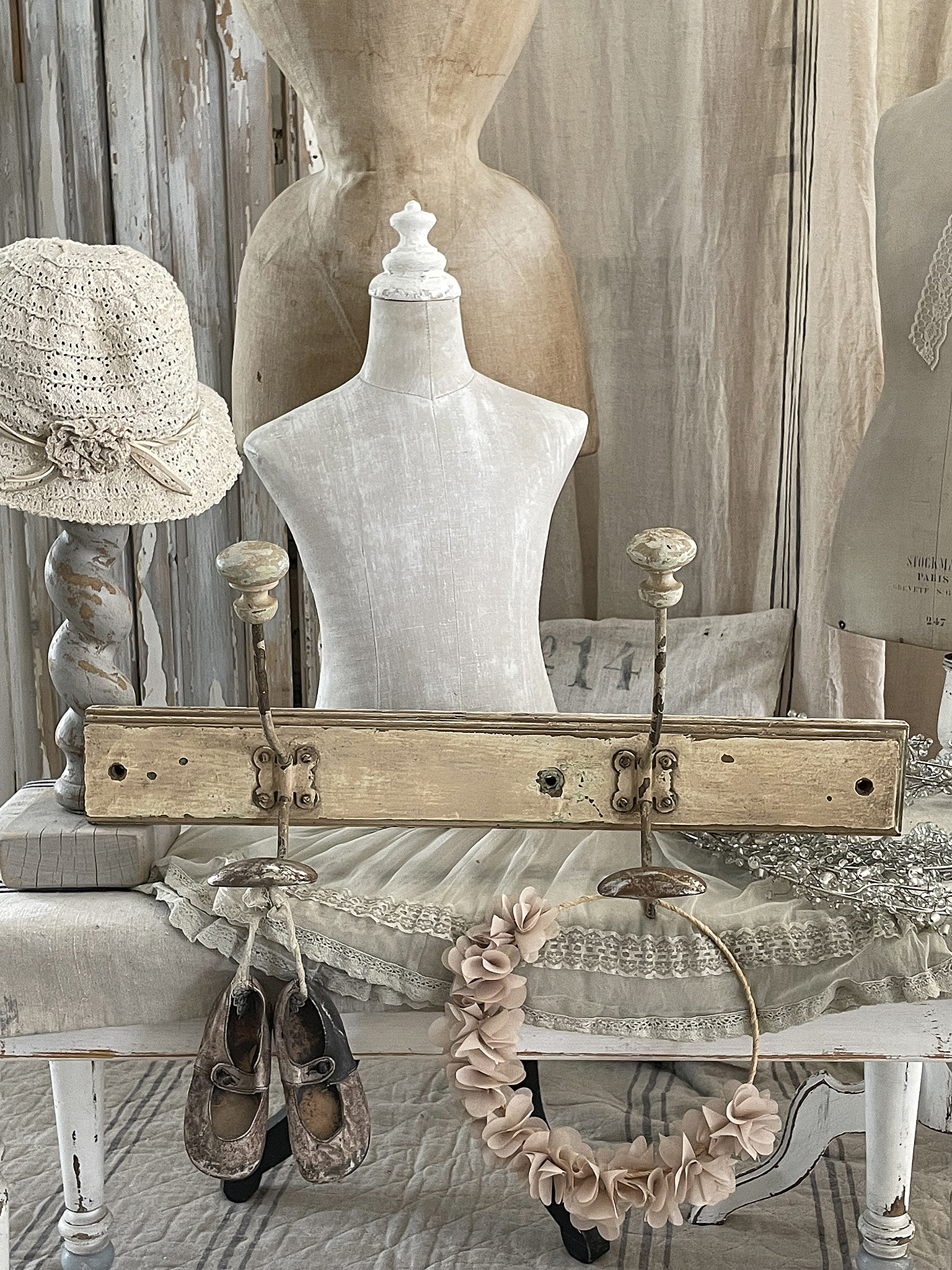 Rustikale Boutique-Dekoration mit Kleiderständer und Accessoires Stilvolle Anordnung von Vintage-Kleidern, Schuhen und Accessoires auf einem Tisch