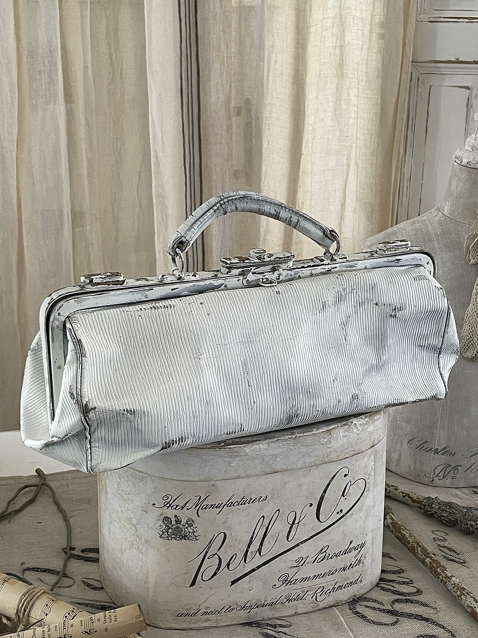 Vintage Handtasche auf einem dekorativen Behälter Stilvolle Vintage Handtasche auf einem eleganten Behälter mit Beschriftung
