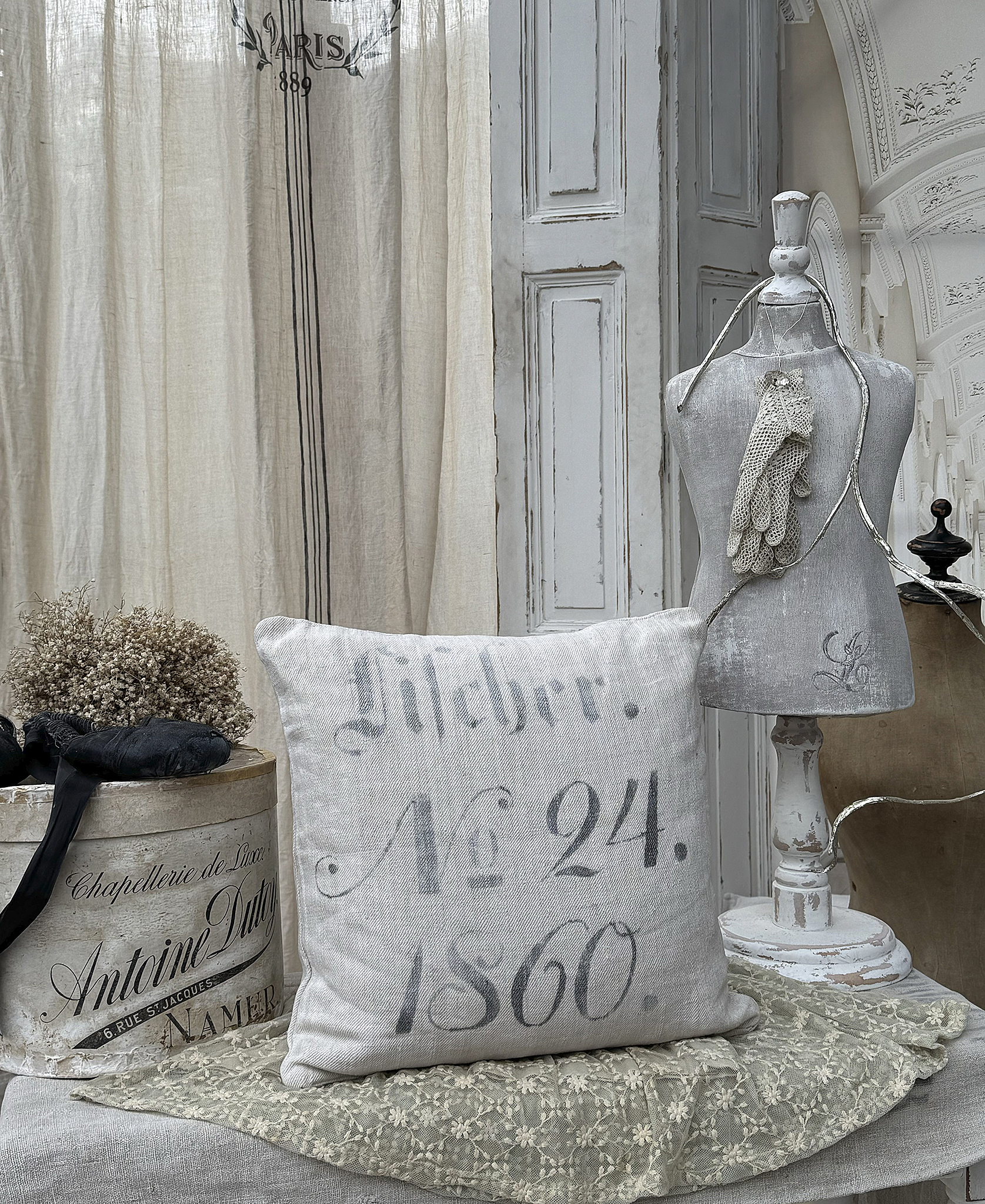 Dekoratives Kissen im Vintage-Stil mit Aufdruck Nummer 24, 1860, auf einem rustikalen Tisch im Landhausstil.