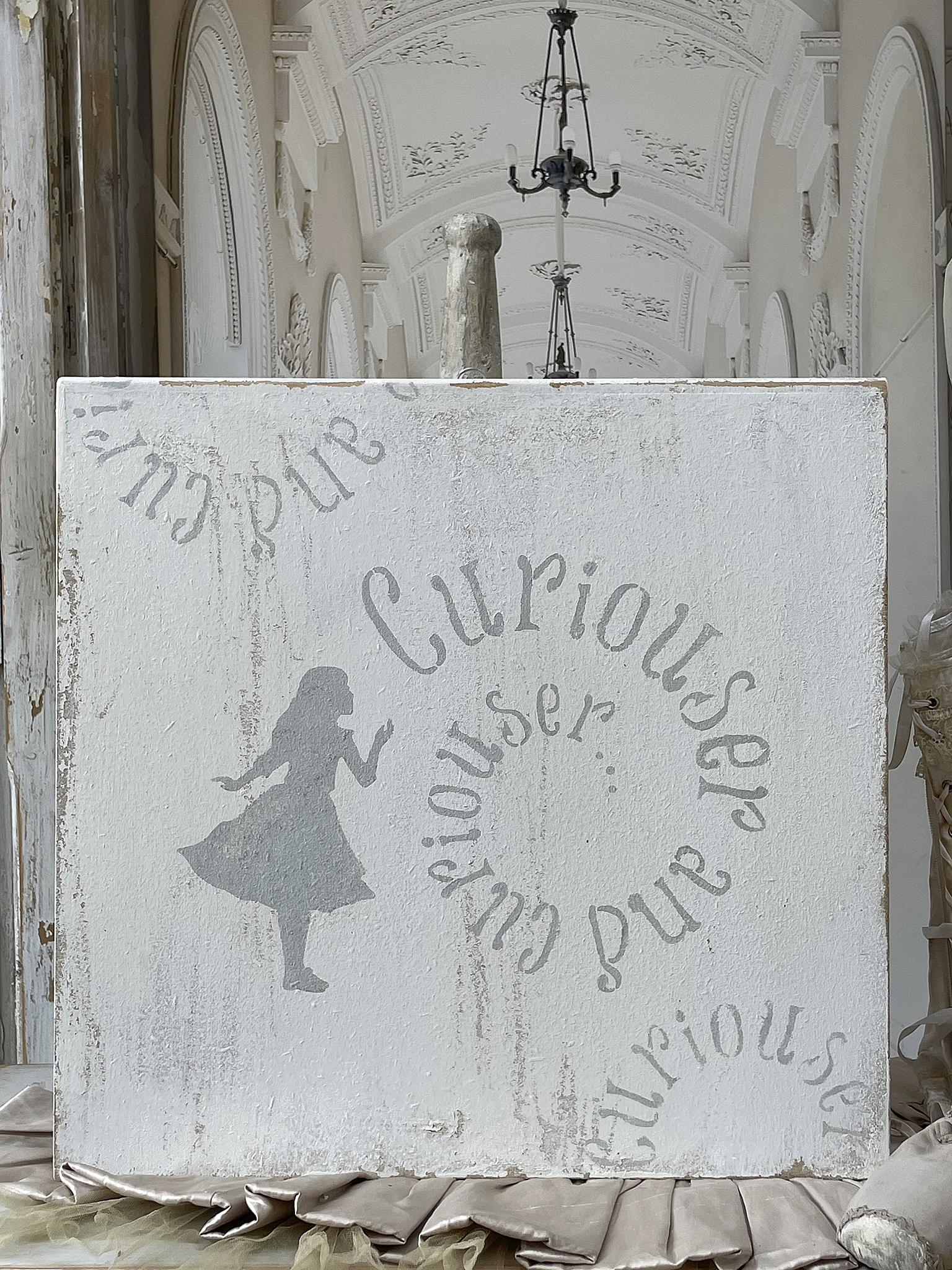 Kreative Wanddekoration mit silberner Schrift und Silhouette Wandbild mit dem Text 'Curious' und einer tanzenden Silhouette in elegantem Design