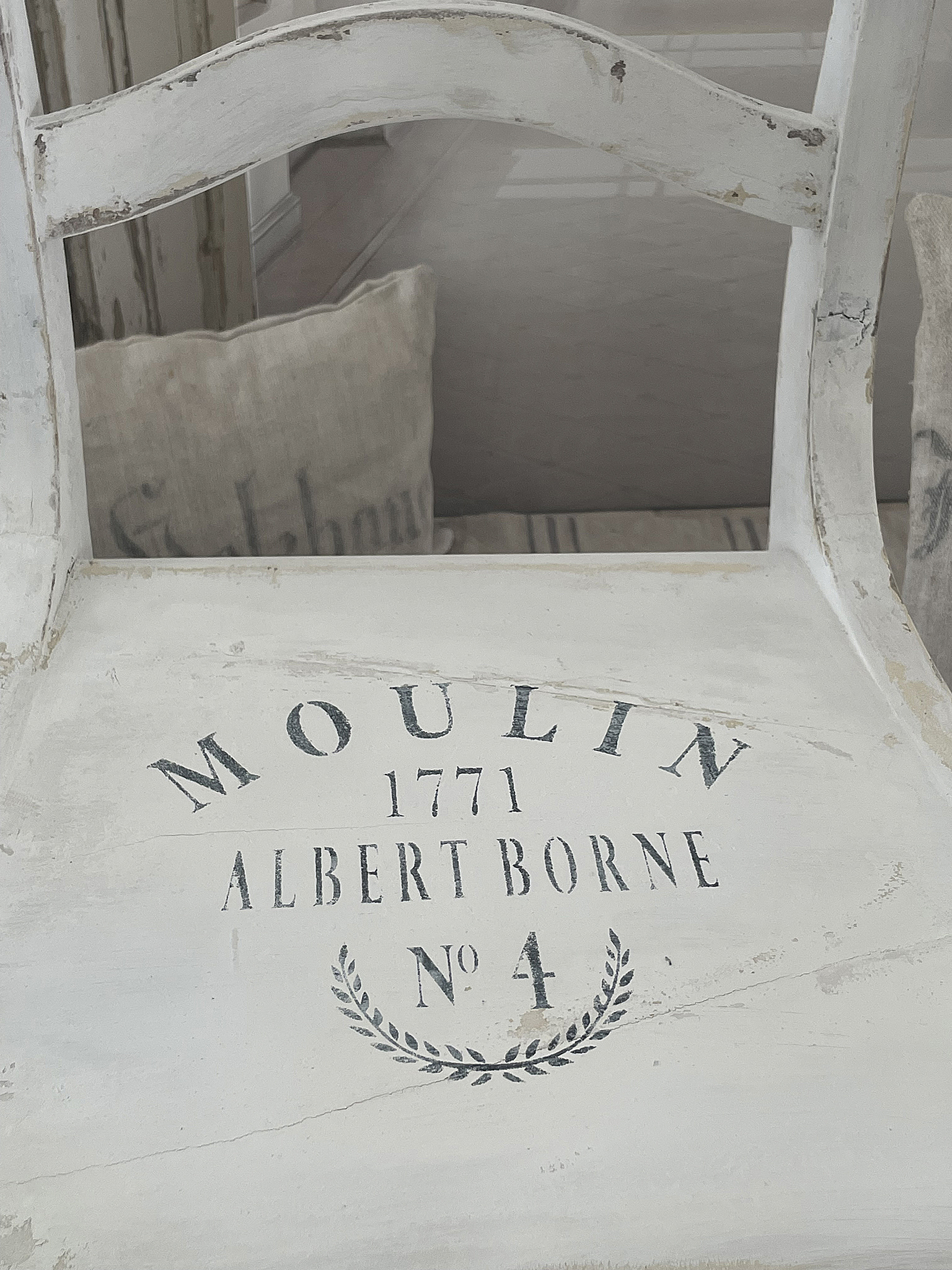 Antiker Stuhl mit französischer Beschriftung Moulin Albert Borne 1771 Detailansicht eines antiken Stuhls mit der Inschrift Moulin Albert Borne 1771 und botanischen Motiven.