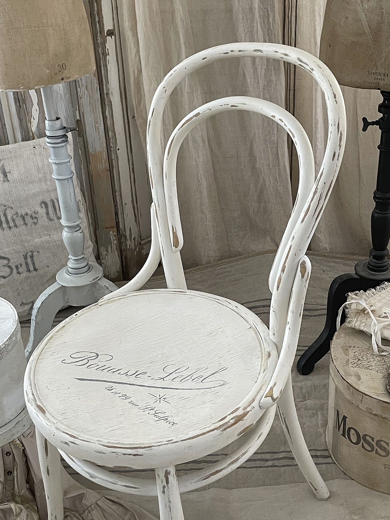 Eleganter weißer Stuhl mit Vintage-Design Weißer Stuhl im Vintage-Stil mit dekorativem Schriftzug auf der Sitzfläche.