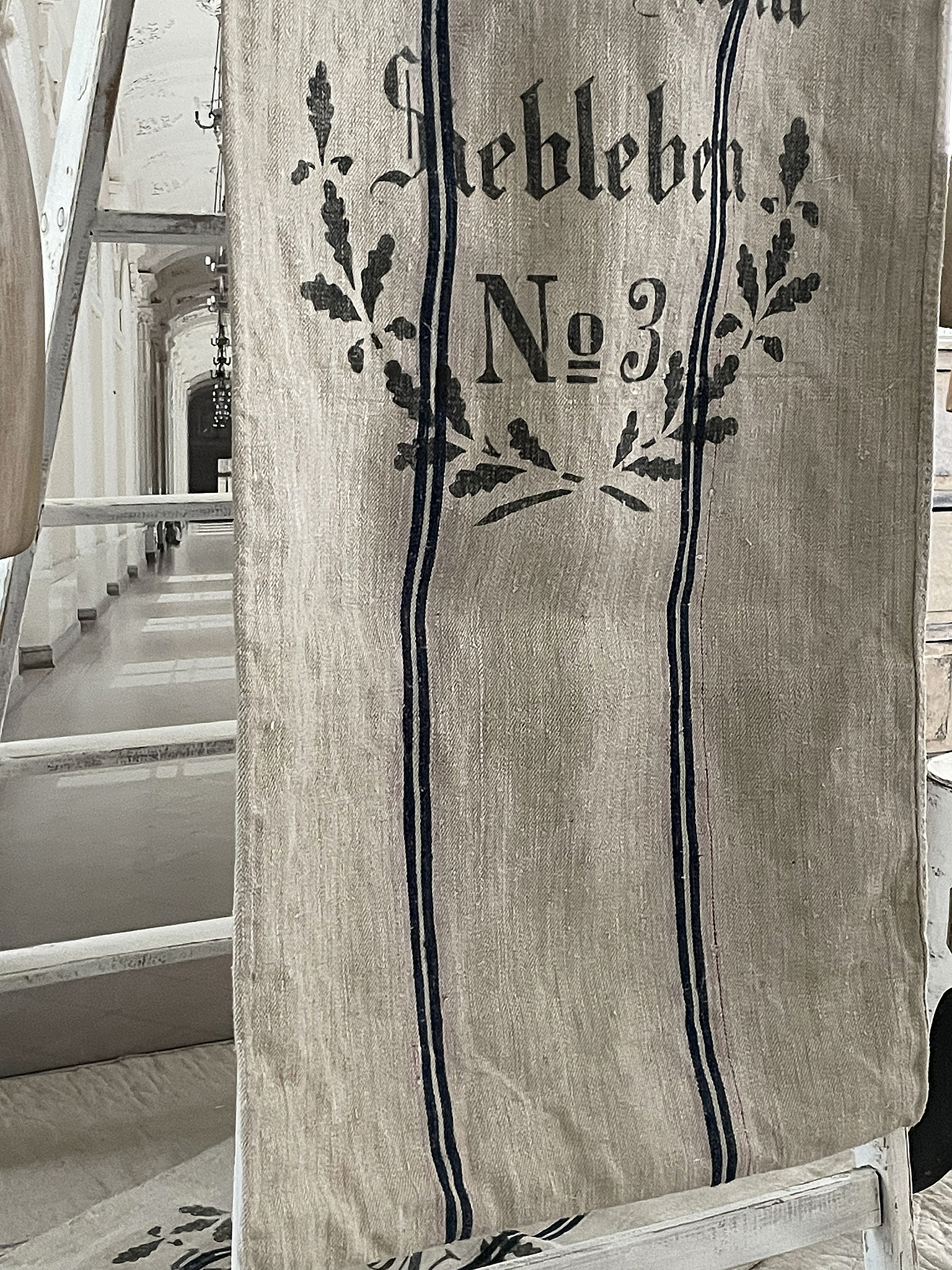 Aufnahme eines vintage Leinenstoffes mit der Aufschrift 'Liebleben No3' und floralem Muster.