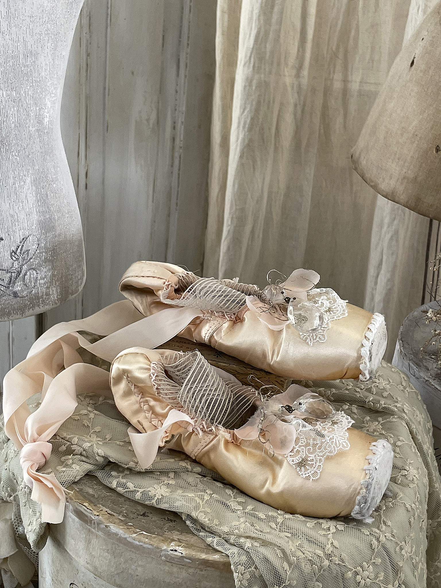 Elegante Ballettschuhe aus Satin mit Rüschen und Schleifen Zwei elegante Ballettschuhe aus satin mit filigranen Details auf einem Tisch