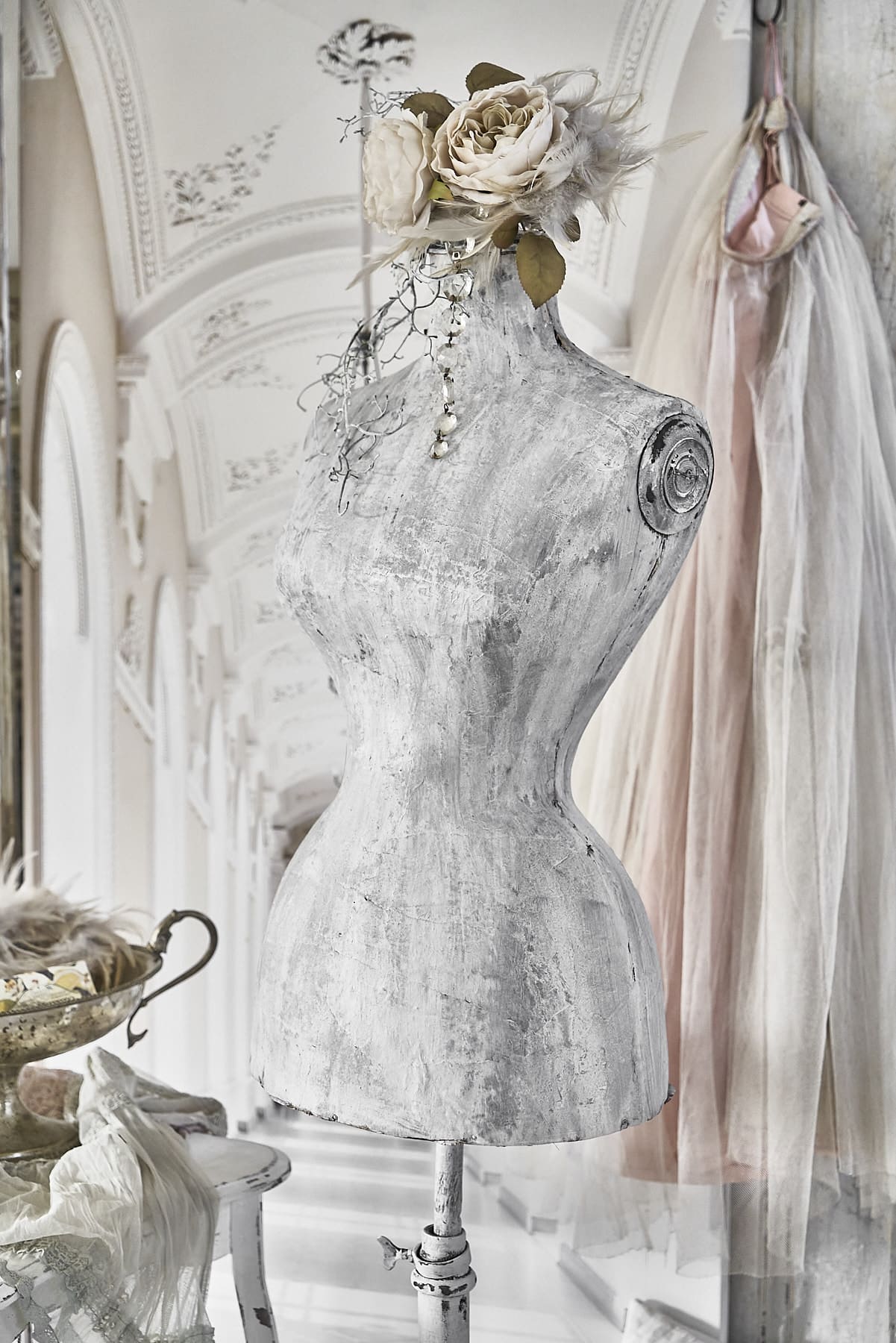 Schneiderpuppe in vintage Stil mit rosa Rosen und zarten Accessoires im Hintergrund