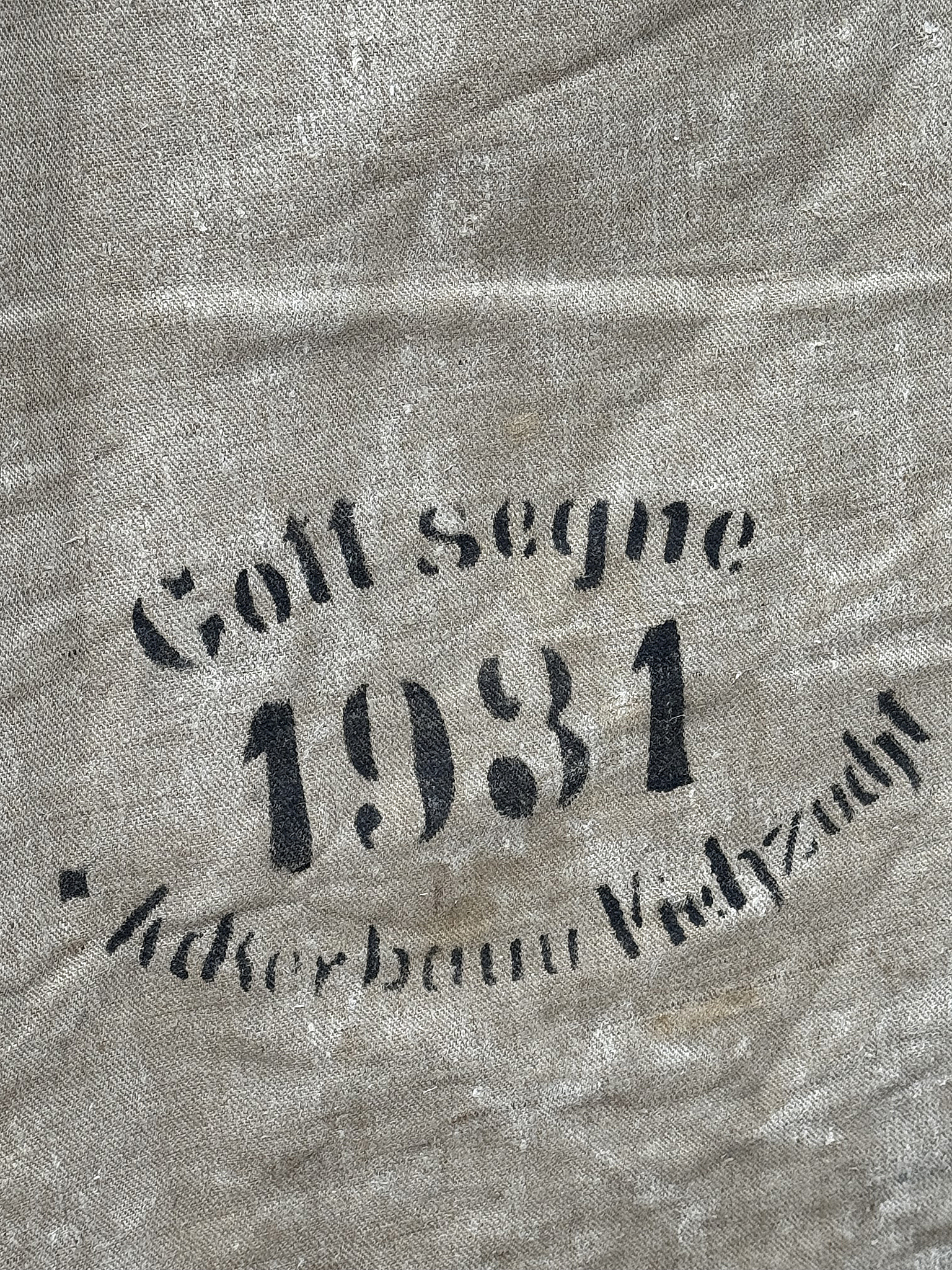 Stoffbeutel mit Schriftzug "Gott segne 1981" und Namen aus der Vergangenheit Detailaufnahme eines Stoffbeutels mit der Aufschrift "Gott segne 1981" und "Äckerbaum Viezzeit".