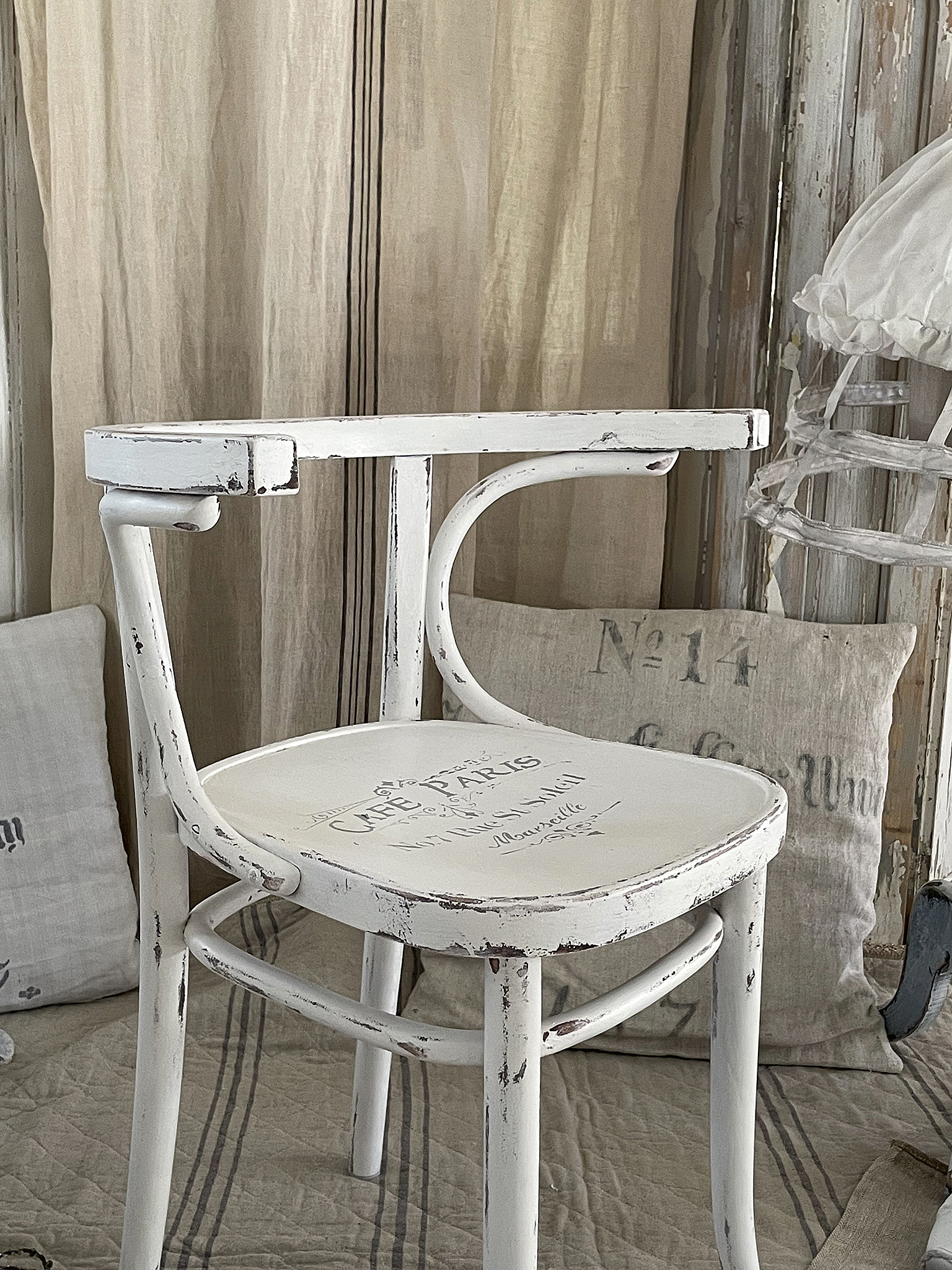 Klassischer weißer Stuhl mit Vintage-Design Weißer Stuhl im Vintage-Stil mit abgenutzter Oberfläche und Caféschriftzug