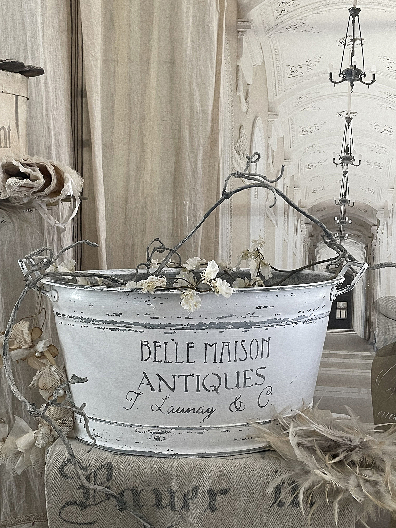 Antikes Deko-Element von Belle Maison Antiques mit Zweigen und Blumen Dekoration mit antikem Eimer von Belle Maison Antiques, verziert mit floralen Elementen und einem eleganten Hintergrund.