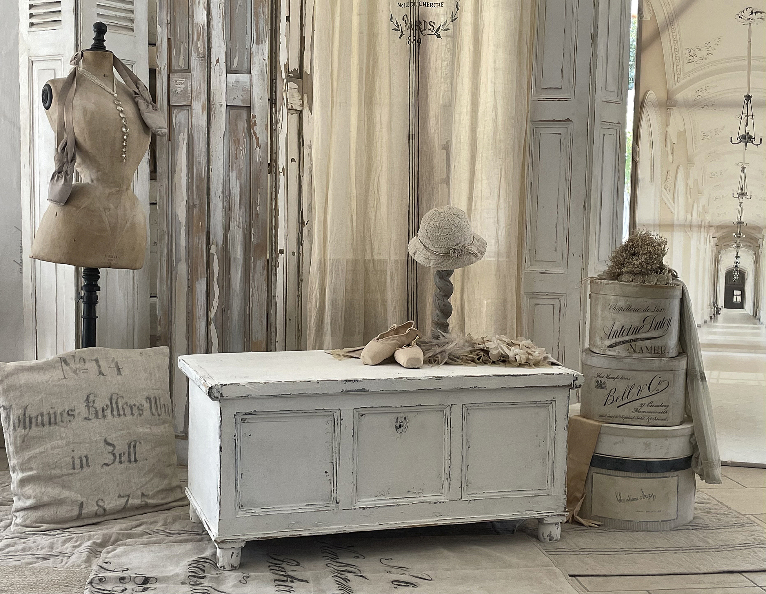 Kreatives Vintage-Dekor mit Mannequin und antiken Accessoires Gemütliche Einrichtung mit einer weißen Truhe, einem Mannequin und Vintage-Hüten