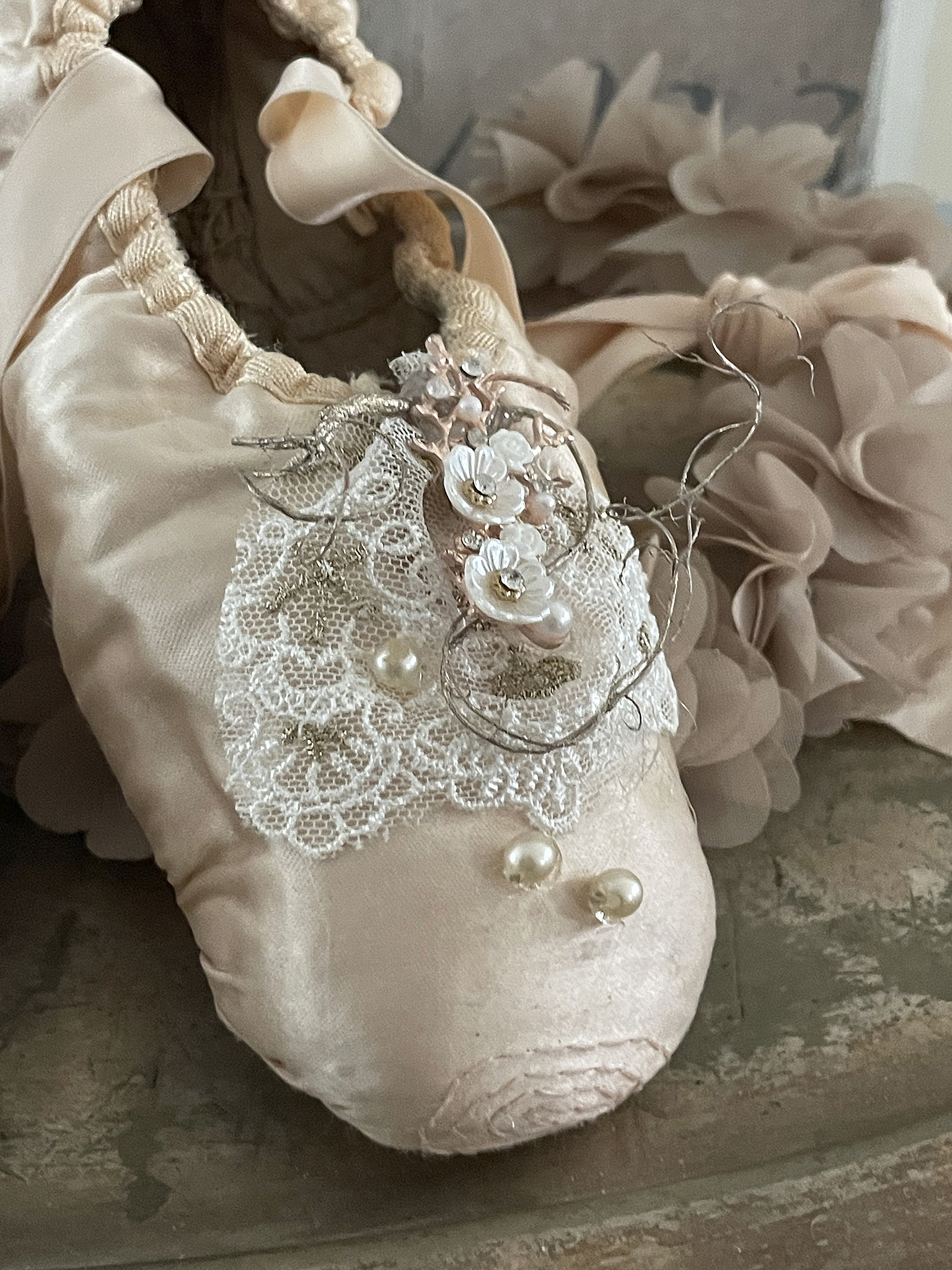 Elegante Ballettschuhe mit kunstvoller Verzierung Detailaufnahme von verzierten Ballettschuhen in cremefarben mit Spitzen und Perlen