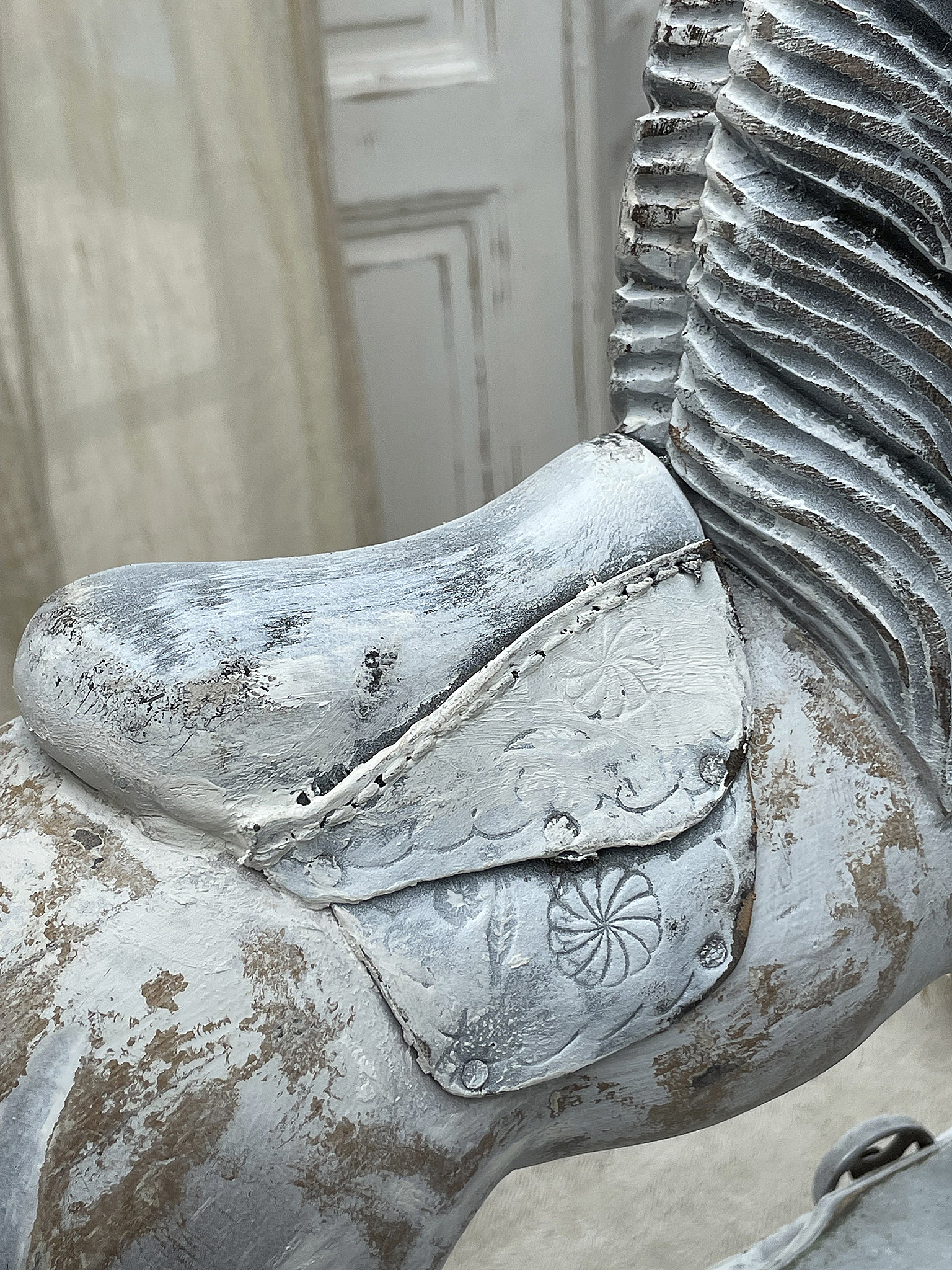 Schöner Sattel eines nostalgischen Holzpferdes in Grau- und Weißtönen