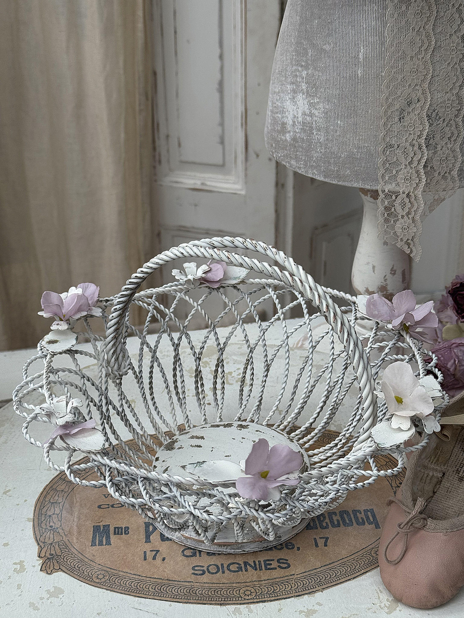Dekorativer Korb mit zarten Blumen in Pastellfarben Zarter, weißer Korb mit dekorativen Blumen auf einem vintage Untergrund