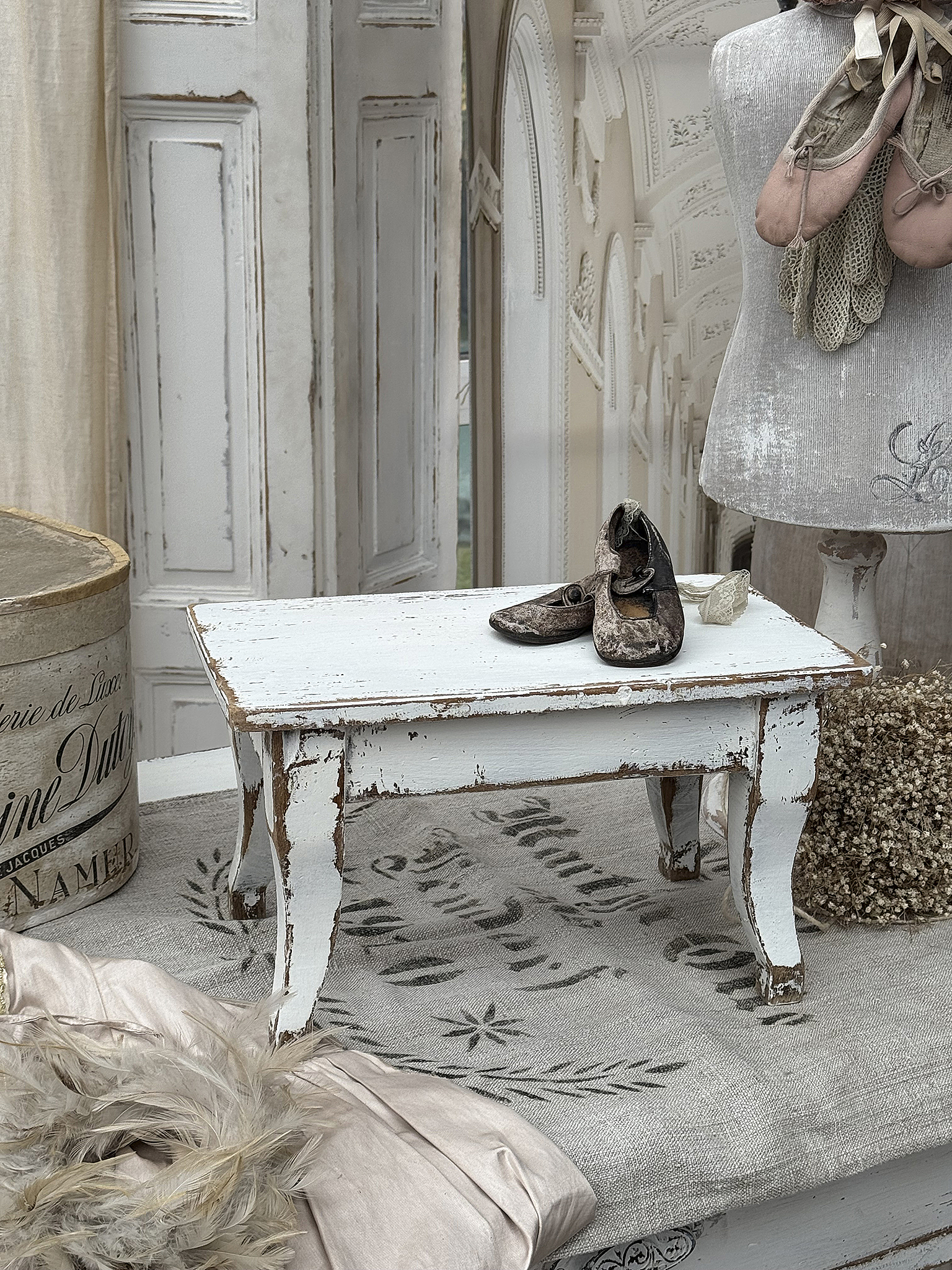 Vintage weißer Beistelltisch mit antikem Flair Weißer Beistelltisch im Shabby-Chic-Stil mit alten Ballettschuhen und Dekoration
